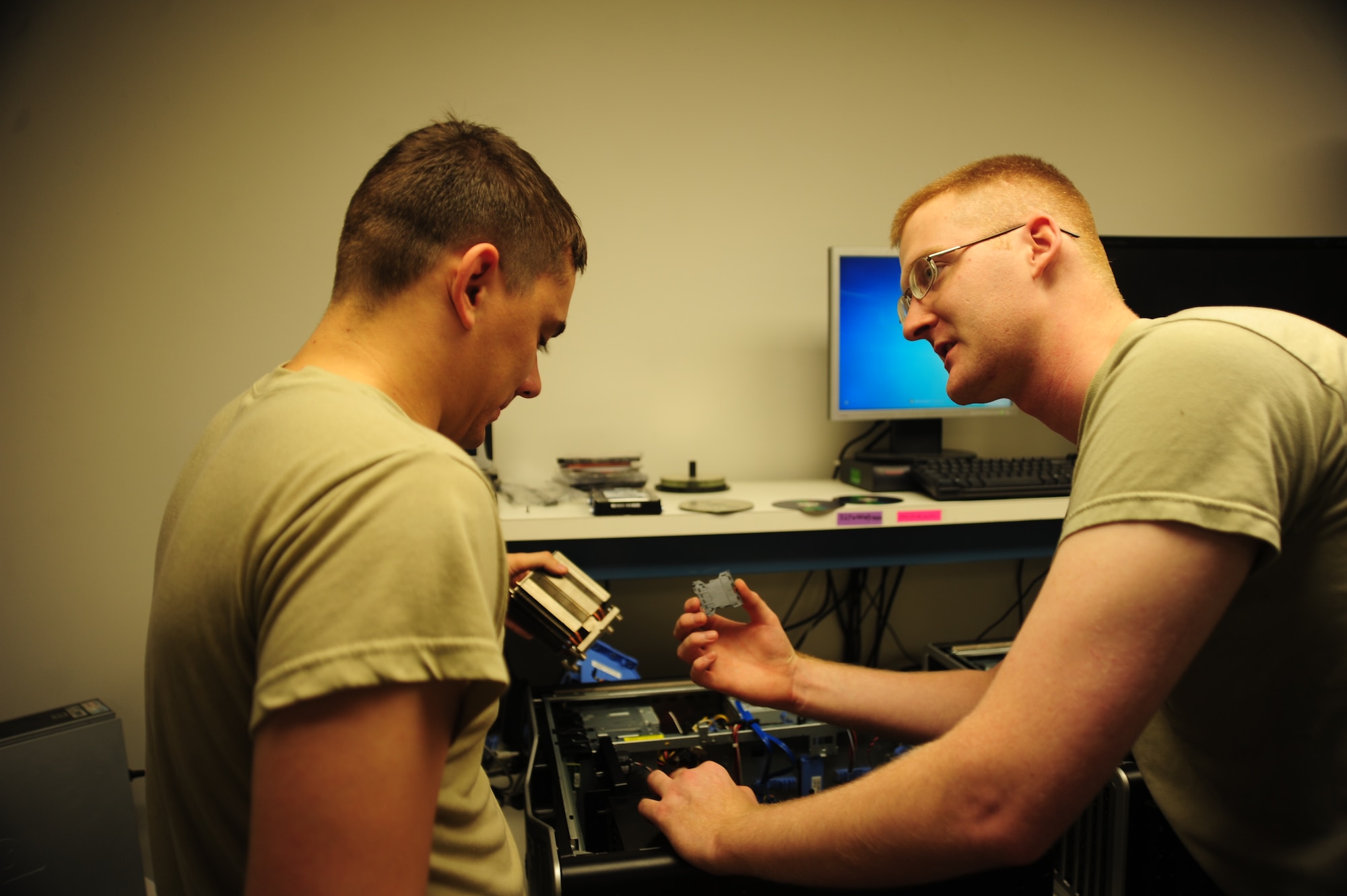 WHITEMAN AIR FORCE BASE, Mo. -- Staff Sgt. Justin Guyor, 509th Communications Focal point assistant NCOIC, teaches Senior Airman Wesley Snider, 509th CS client services technician, what to look for before installing a processor into a computer Sept. 6. The computer’s processor performs basic arithmetical, logical and input/output operations of a system. (U.S. Air Force photo/Senior Airman Nick Wilson) (Released)