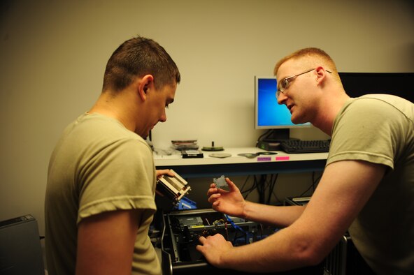 WHITEMAN AIR FORCE BASE, Mo. -- Staff Sgt. Justin Guyor, 509th Communications Focal point assistant NCOIC, teaches Senior Airman Wesley Snider, 509th CS client services technician, what to look for before installing a processor into a computer Sept. 6. The computer’s processor performs basic arithmetical, logical and input/output operations of a system. (U.S. Air Force photo/Senior Airman Nick Wilson) (Released)