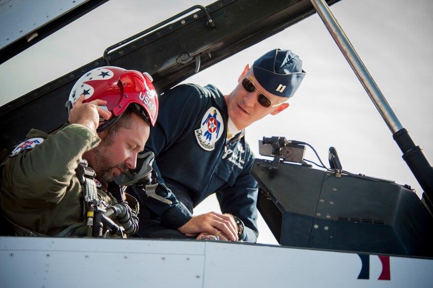 Lt. Joseph Dukes, Lowndes County Sheriff’s Department, puts on a flight helmet with assistance from Capt. Michael Fisher, U.S. Air Force Thunderbird 8, advance pilot, during the Moody Air Force Base, Ga., Legacy of Liberty Open House air show Oct. 26, 2012. Dukes was selected for the opportunity based on his various sacrifices and commitment within the sheriff’s department. (U.S. Air Force photo by Staff Sgt. Jamal D. Sutter/Released)  