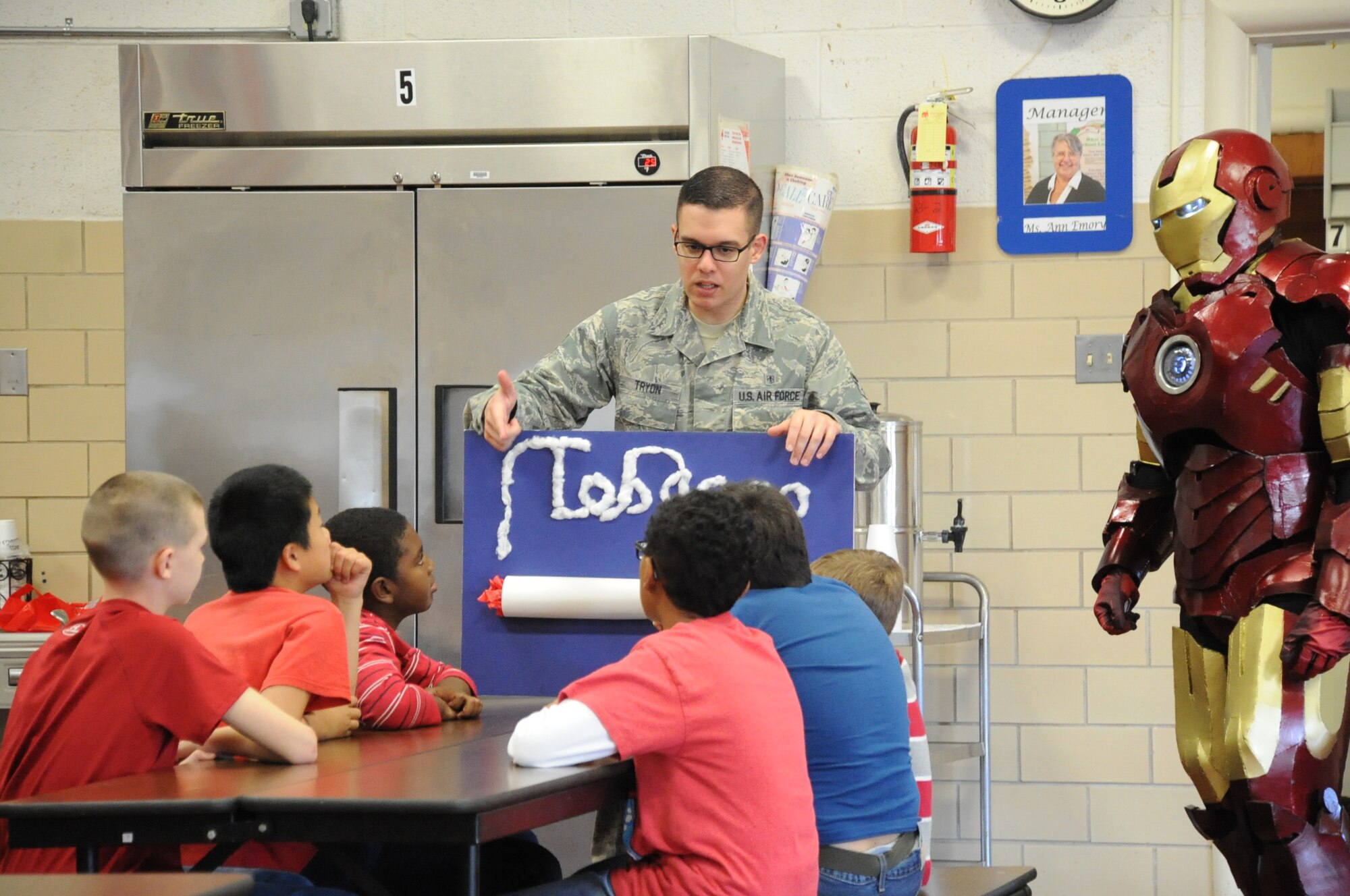 Senior Airman Michael Tryon and Technical Sgt. Olsen Betron (dressed as Iron Man) explain the effects of tobacco to a group of sixth grade students during Red Ribbon week at Sheppard Elementary School. (U.S. Air Force Photo/Kimberly Parker)