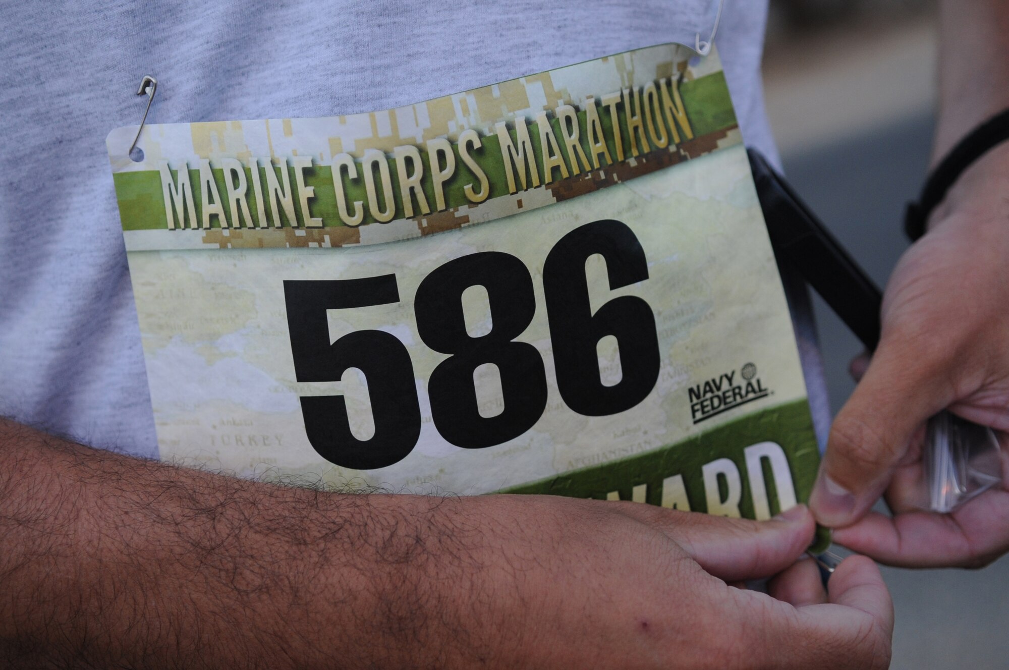 SOUTHWEST ASIA – Second Lt. Matthew Bracy, 386th Expeditionary Logistics Readiness Squadron passenger services Officer-In-Charge, pins his number on his shirt prior to participating in the U.S. Marine Corps Marathon Forward here Oct. 28.  Approximately 60 service members gathered to participate in the 26.2 mile test of endurance.  (U.S. Air Force photo/Staff Sgt. Alexandra M. Boutte)