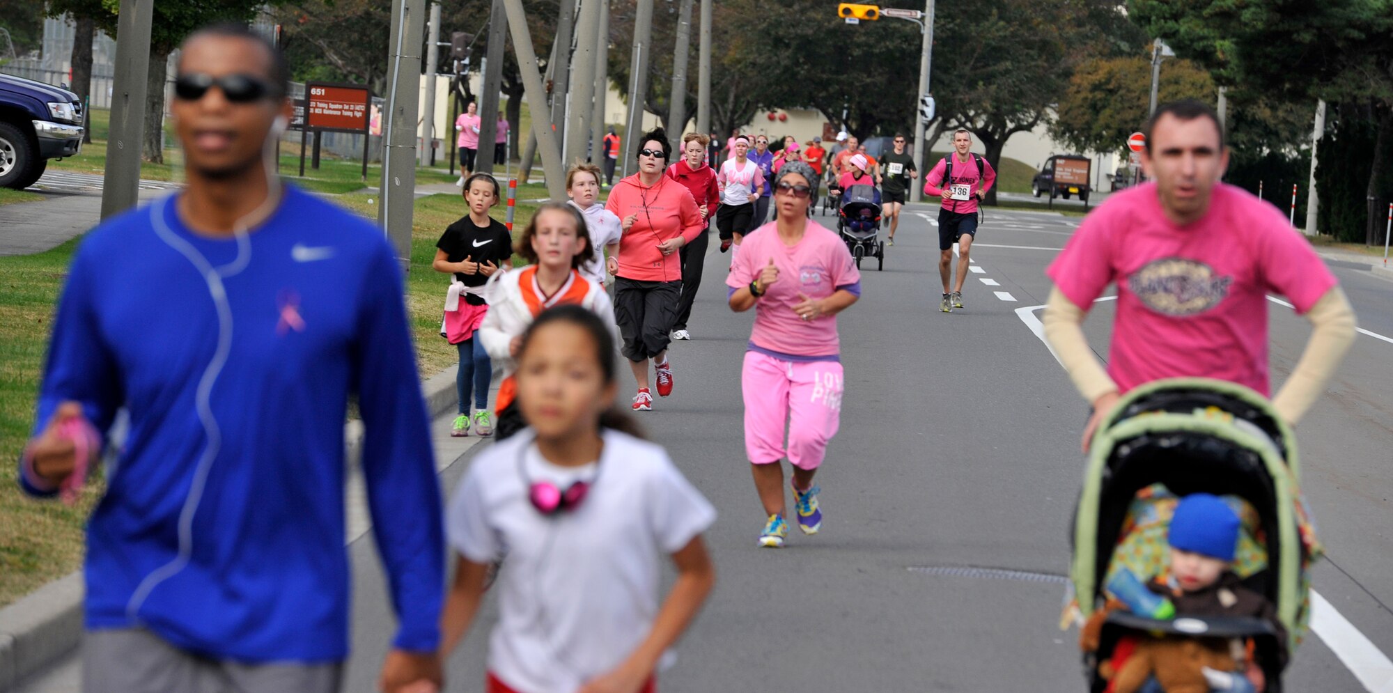 Runners make their way to the finish line during the Breast Cancer Run 2012 at Misawa Air Base, Japan, Oct. 27, 2012. More than 300 people participated in the event to help raise breast cancer awareness. Top times included a 51 minute, 46 seconds perimeter run by a male and 1 hour, 9 seconds by a female. (U.S. Air Force photo by Airman 1st Class Zachary Kee)