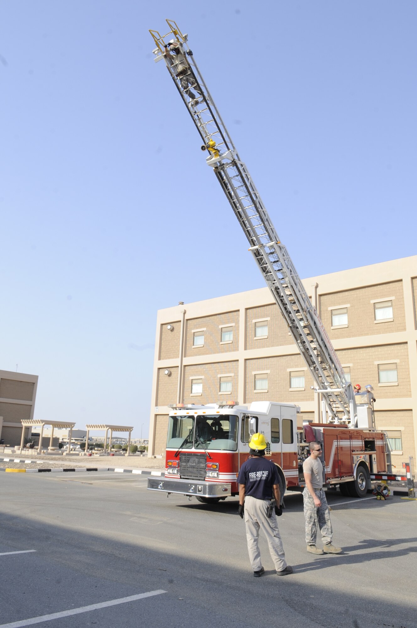 HWEST ASIA – Members of the 386th Expeditionary Civil Engineer Squadron fire department, operates the 77-foot ladder to perform aerial rescue from different levels of a building and elevates them to run water from their position here Sept. 28. (U.S. Air Force photo/Staff Sgt. Alexandra M. Boutte)