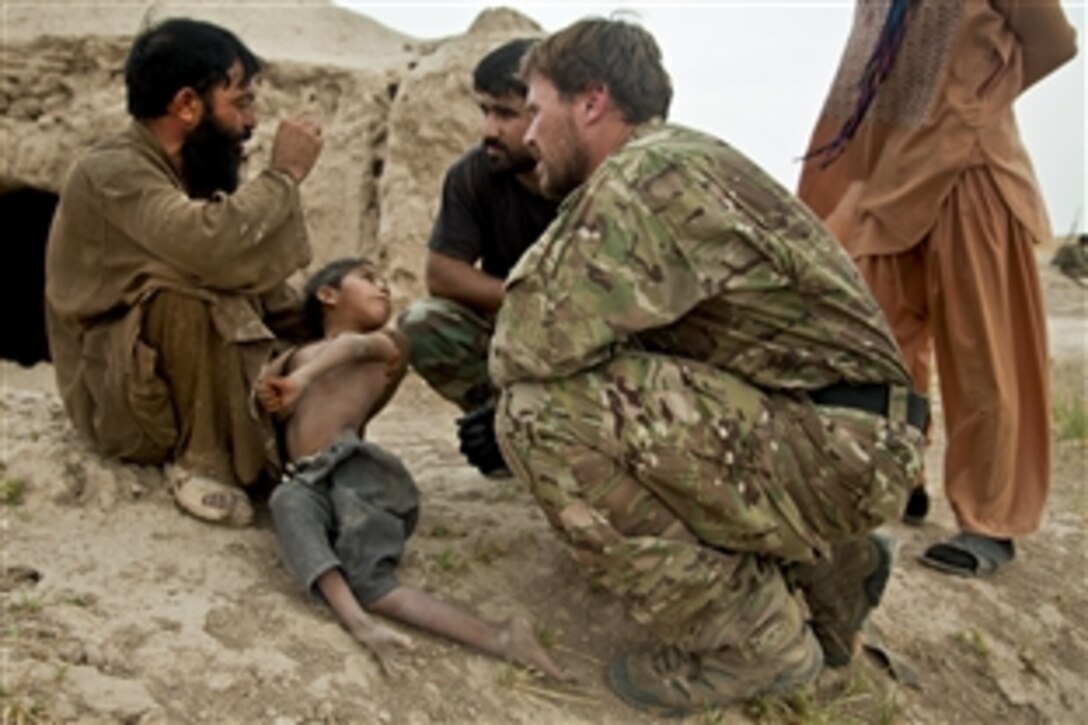 A coalition force member assesses a child's health during an Afghan-led security patrol to deny freedom of movement for the enemy in Khak-E-Safed in Afghanistan's Farah province, Oct. 30, 2012. Afghan forces have been taking the lead in security operations, with coalition forces as mentors to bring security and stability to the country's people.