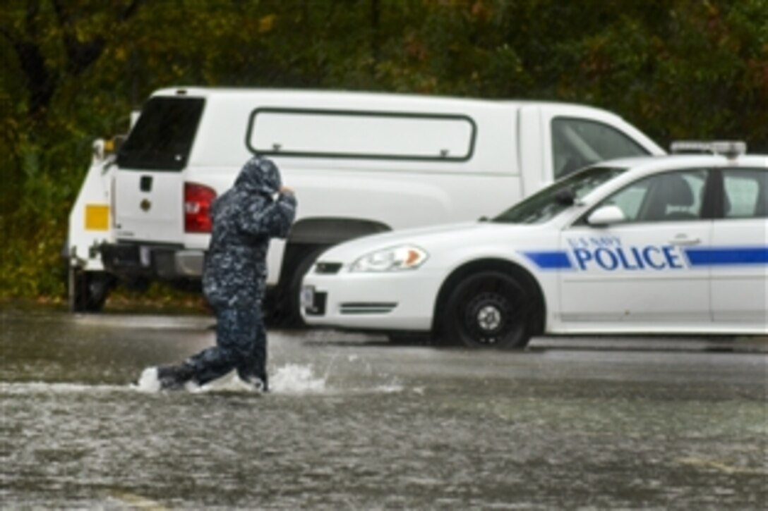A sailor walks through a flooded parking lot to report for duty during Hurricane Sandy at the Naval Air Station Oceana Police Department in Norfolk, Va., Oct. 29, 2012. The air station has experienced flooding and downed trees from weather conditions associated with the hurricane.