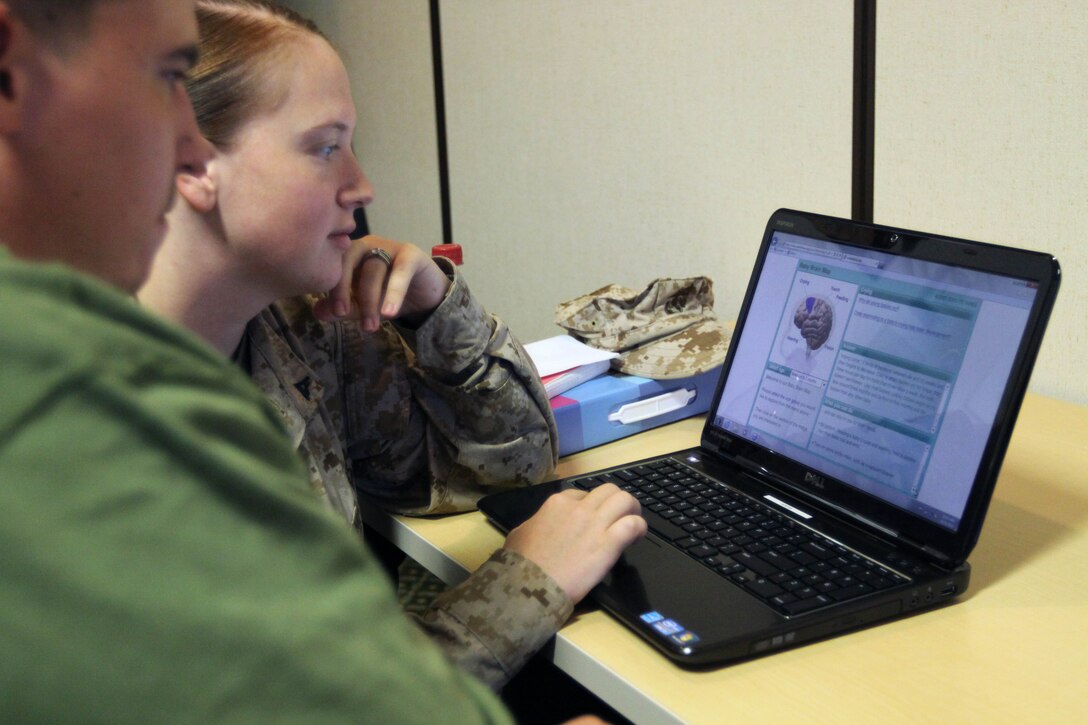 Lance Cpl. Jennifer M. Wolfe, a distribution management specialist, for 1st Supply Battalion’s distribution management office with her husband and stay-at-home dad, Donald Q. Wolfe view a digital baby-brain map during Operation Parenthood, an early childhood training at the Family Readiness Center here Oct. 31.