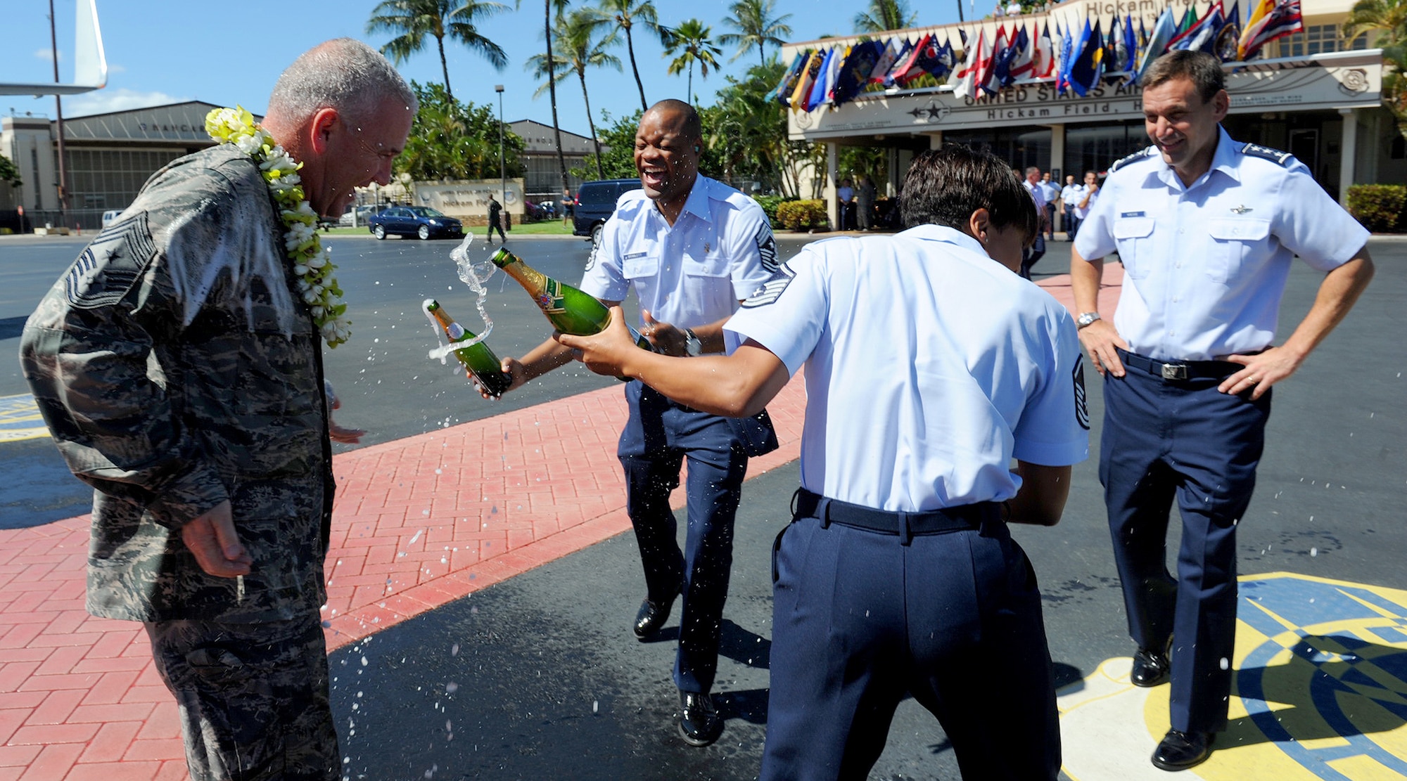 Left to right, Chief Master Sgt. Brooke McLean, Pacific Air Forces command chief, gets hosed down with champagne by Chief Master Sgt. Leslie Bramlett, 15th Wing command chief, and Master Sgt. Michelle L. Kern, superintendent, force management, PACAF 647th Force Support Squadron, as Lt. Gen. Stanley “Ted” Kresge, PACAF vice commander, waits to congratulate the chief shortly after his “fini flight” at Joint Base Pearl Harbor Hickam-Hawaii, Oct. 29, 2012. McLean served 30 years in the Air Force and will retire Nov. 16, 2012 at JBPH-H, Hawaii. (U.S. Air Force photo/Tech. Sgt. Jerome S. Tayborn/Released)