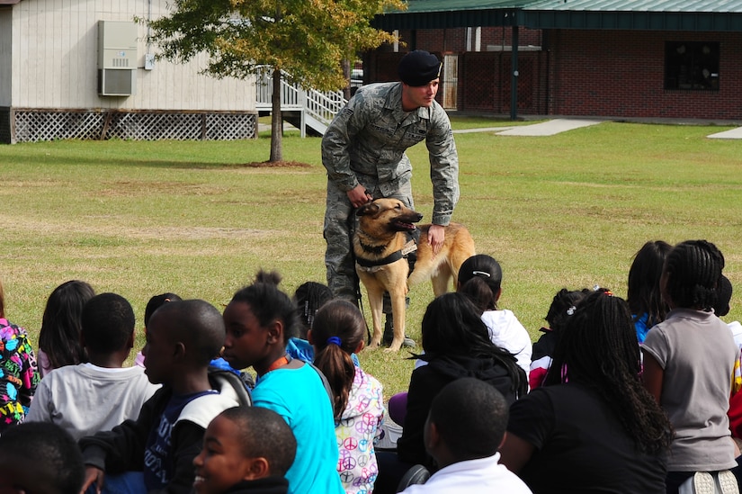 Senior Airman Joel Patterson, 628th Security Forces Squadron K-9 handler, pets his military working dog Elmo during a drug-detection demonstration for Red Ribbon Week Oct. 30, 2012, at Hunley Park Elementary School, North Charleston, S.C. The theme of this year’s campaign is "The Best Me Is Drug Free." The campaign began after the 1985 murder of Federal Drug Enforcement Administration Agent, Enrique Camarena, while he was investigating Mexican drug traffickers. Red Ribbon Week allows educators, parents, community groups, students and others to focus on the work being done by the many who have pledged to live drug free. (U.S. Air Force photo/ Airman 1st Class Chacarra Walker)