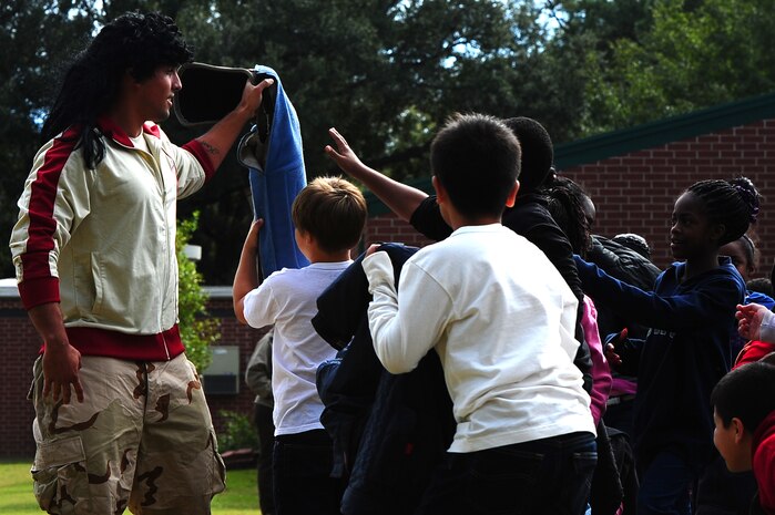 Senior Airman Luis Diaz Garcia, 628th Security Forces Squadron K-9 handler, shows the children the arm pad used for a drug-detection demonstration for Red Ribbon Week Oct. 30, 2012, at Hunley Park Elementary School, North Charleston, S.C. This year's theme is "The Best Me Is Drug Free." This campaign came about after the murder of Federal Drug Enforcement Administration Agent, Enrique Camarena, in 1985, while he was investigating Mexican drug traffickers. Now a national celebration, Red Ribbon Week, allows educators, parents, community groups, students and others to focus on the work being done by the many who have pledged to live drug free. (U.S. Air Force photo/ Airman 1st Class Chacarra Walker)