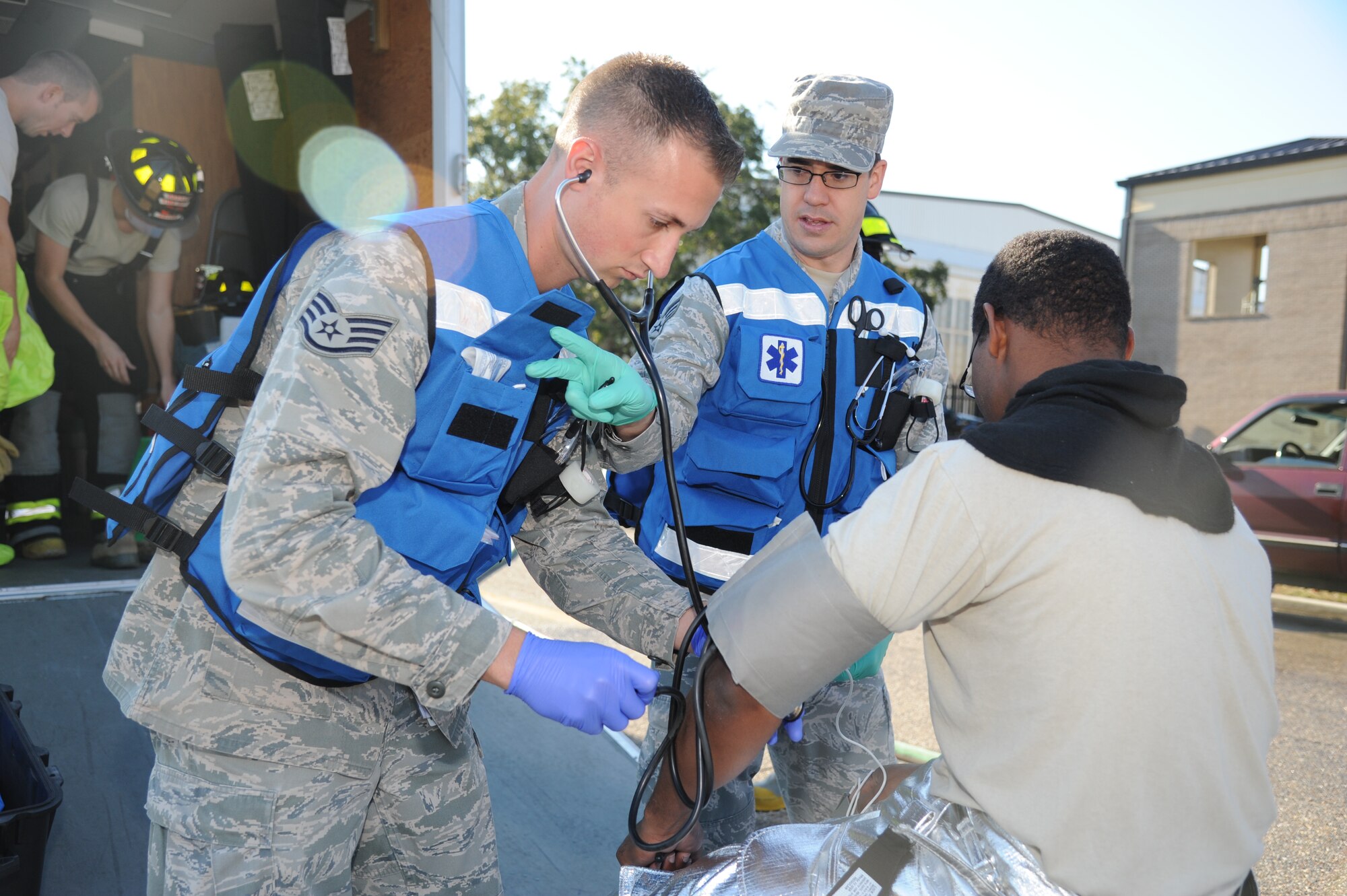 Staff Sgt. Jason Evans and Senior Airman Kyle Costello, 81st Medical Operations Squadron, check vital sign of Jeffery Spivey, Keesler firefighter, before he suits up in safety gear for decontaminating “victims” during a hazardous material and major accident response exercise Oct. 31, 2012, at Hangar 4, Keesler Air Force Base, Miss.  The exercise scenario consisted of a group of Airmen cleaning inside the hangar in preparation for demolition when a shelf holding old munitions fell to the ground causing one to break open, explode and splash an “oily substance” on several of the “victims.”  The exercise helped prepare first responders in the event of a real-world incident.  (U.S. Air Force photo by Kemberly Groue)