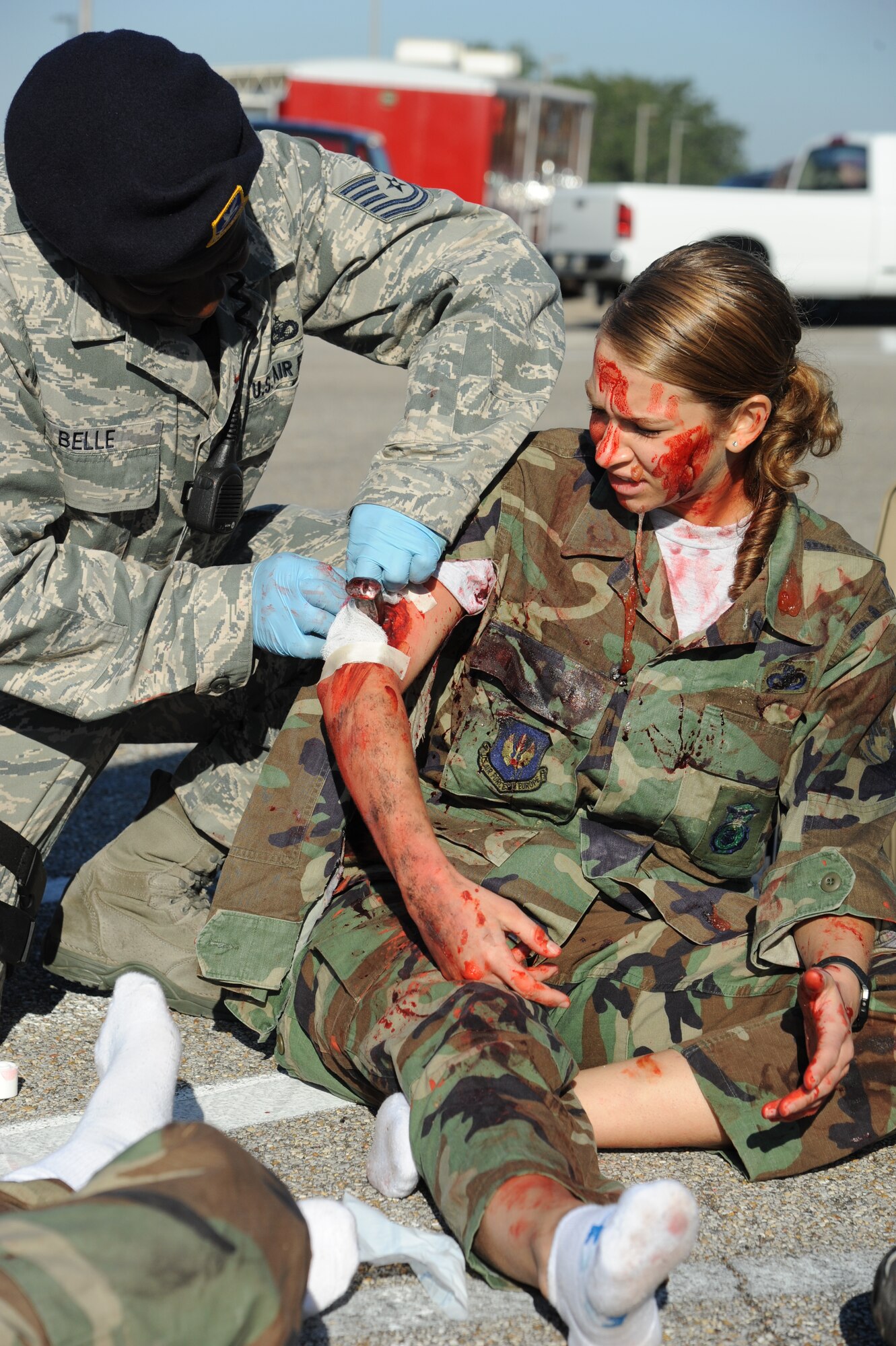 Tech. Sgt. Phillip Belle, III, 81st Security Forces Squadron, administers self aid and buddy care on Airman 1st Class Sarah Kenny, 336th Training Squadron, who portrays an injured “victim” during a hazardous material and major accident response exercise Oct. 31, 2012, at Hangar 4, Keesler Air Force Base, Miss.  The exercise scenario consisted of a group of Airmen cleaning inside the hangar in preparation for demolition when a shelf holding old munitions fell to the ground causing one to break open, explode and splash an “oily substance” on several of the “victims.”  The exercise helped prepare first responders in the event of a real-world incident.  (U.S. Air Force photo by Kemberly Groue)