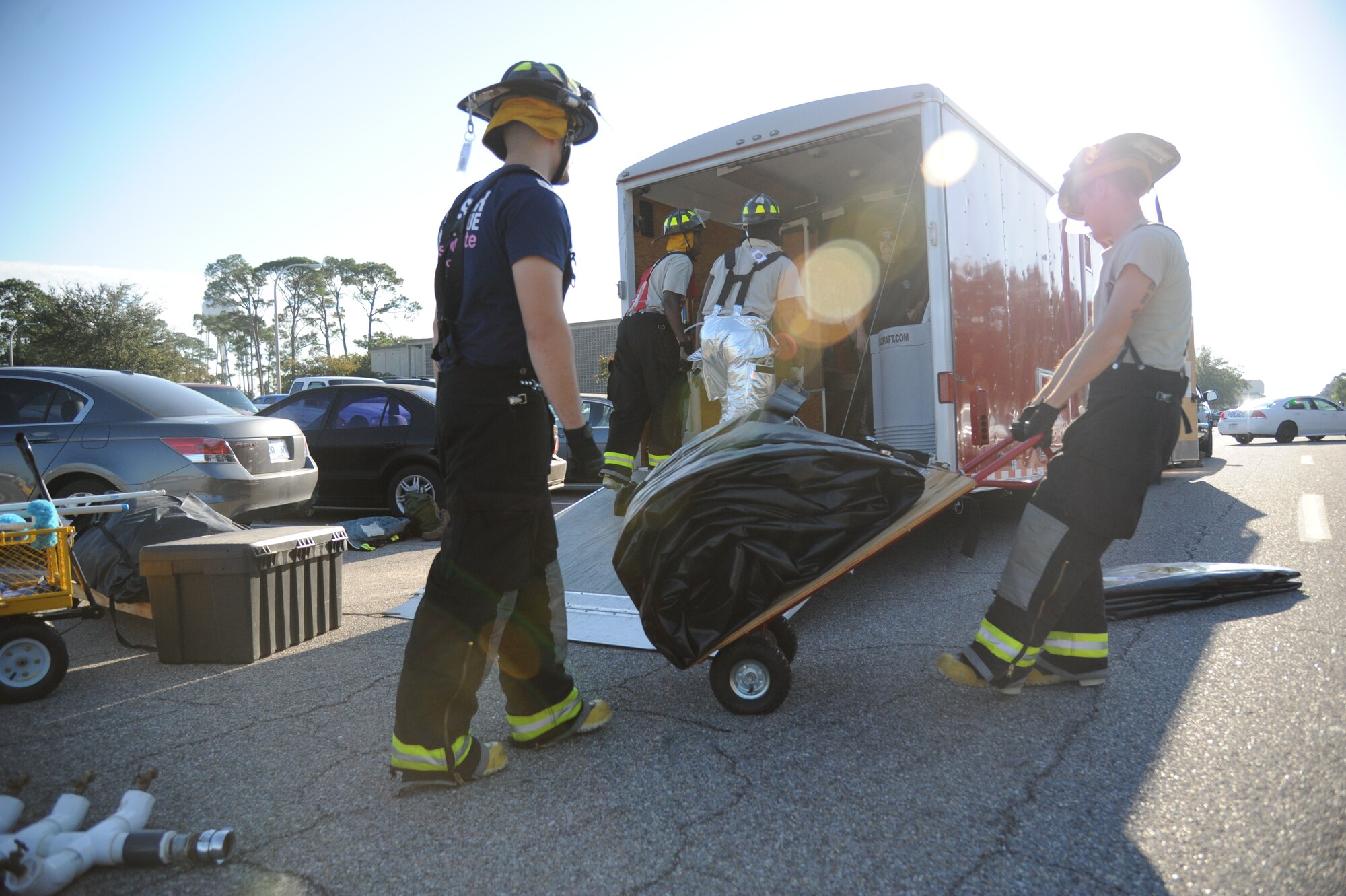 Keesler firefighters unload equipment for assembling a hazardous material decontamination unit during a hazardous material and major accident response exercise Oct. 31, 2012, at Hangar 4, Keesler Air Force Base, Miss.  The exercise scenario consisted of a group of Airmen cleaning inside the hangar in preparation for demolition when a shelf holding old munitions fell to the ground causing one to break open, explode and splash an “oily substance” on several of the “victims.”  The exercise helped prepare first responders in the event of a real-world incident.  (U.S. Air Force photo by Kemberly Groue)