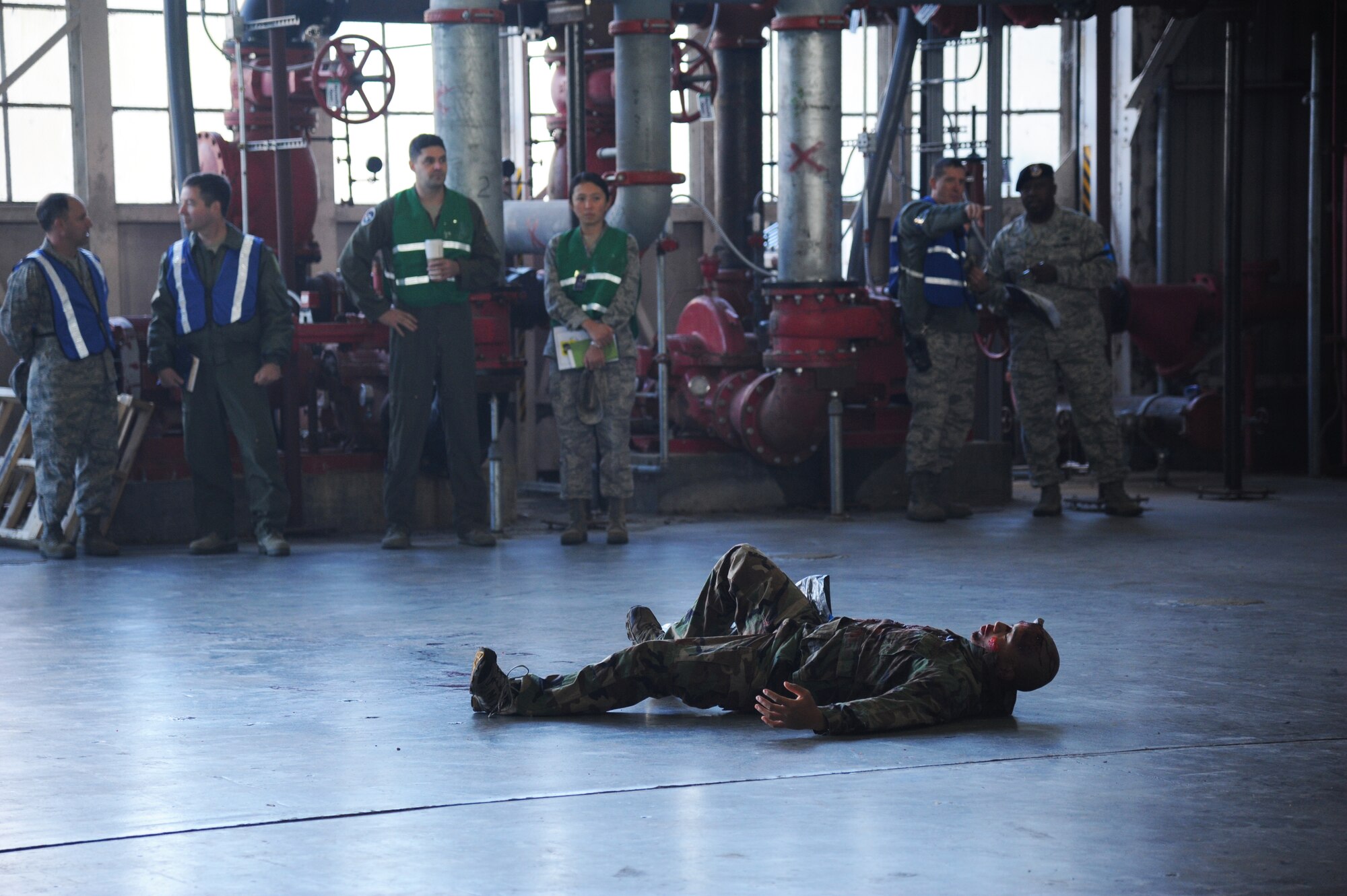 Airman 1st Class Kiel Boutelle, 336th Training Squadron, portrays a “victim” inside hangar 4 who has been injured by an explosion during a hazardous material and major accident response exercise Oct. 31, 2012, at Hangar 4, Keesler Air Force Base, Miss.  The exercise scenario consisted of a group of Airmen cleaning inside the hangar in preparation for demolition when a shelf holding old munitions fell to the ground causing one to break open, explode and splash an “oily substance” on several of the “victims.”  The exercise helped prepare first responders in the event of a real-world incident.  (U.S. Air Force photo by Kemberly Groue)