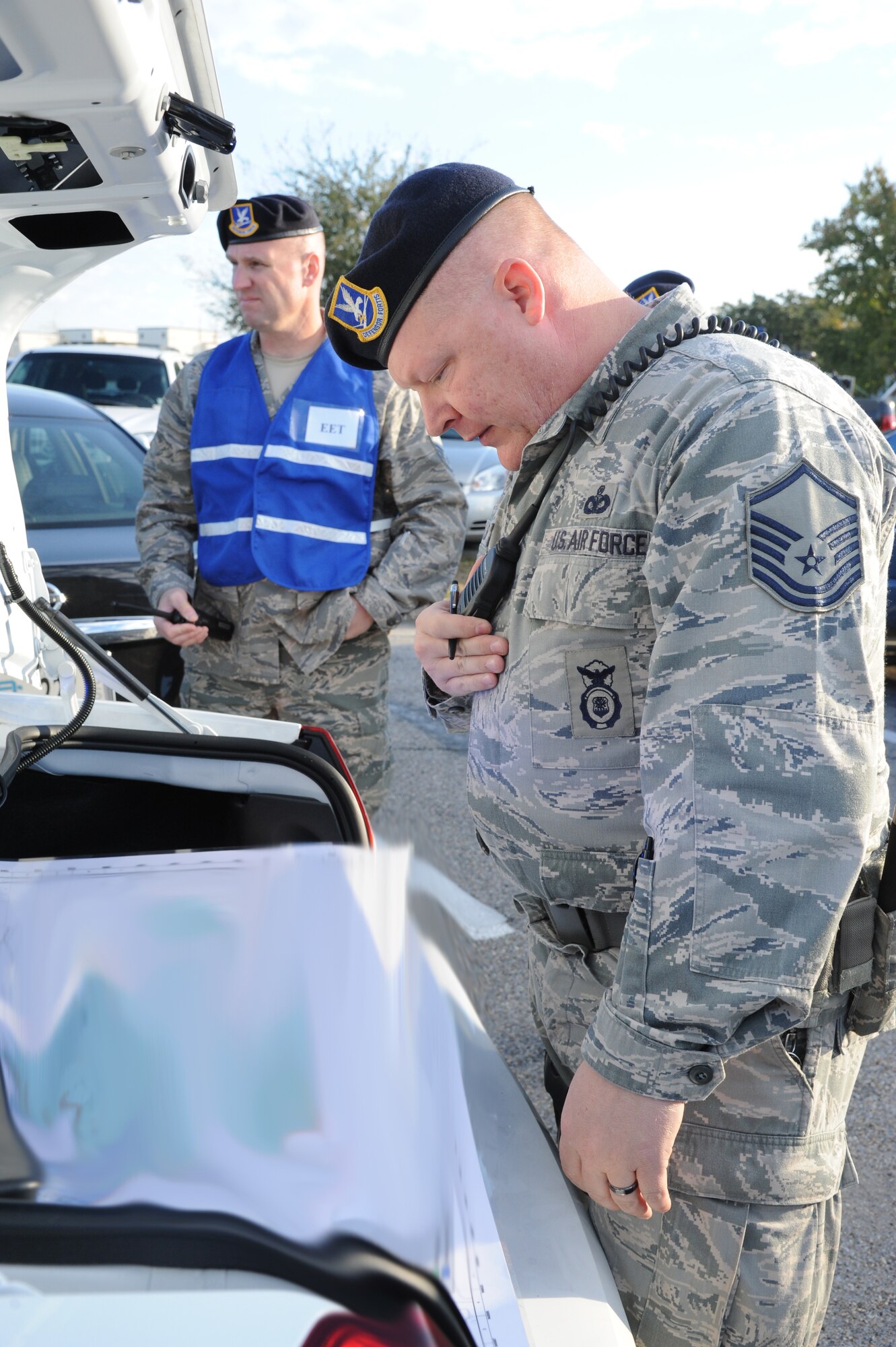 Master Sgt. Damian Phillips, 81st Security Forces Squadron exercise evaluation team member, evaluates 81st SFS personnel as Master Sgt. Billy Waller, 81st SFS, views a map for marking the cordoned areas during the hazardous material and major accident response exercise Oct. 31, 2012, at Hangar 4, Keesler Air Force Base, Miss.  The exercise scenario consisted of a group of Airmen cleaning inside the hangar in preparation for demolition when a shelf holding old munitions fell to the ground causing one to break open, explode and splash an “oily substance” on several of the “victims.”  The exercise helped prepare first responders in the event of a real-world incident.  (U.S. Air Force photo by Kemberly Groue)