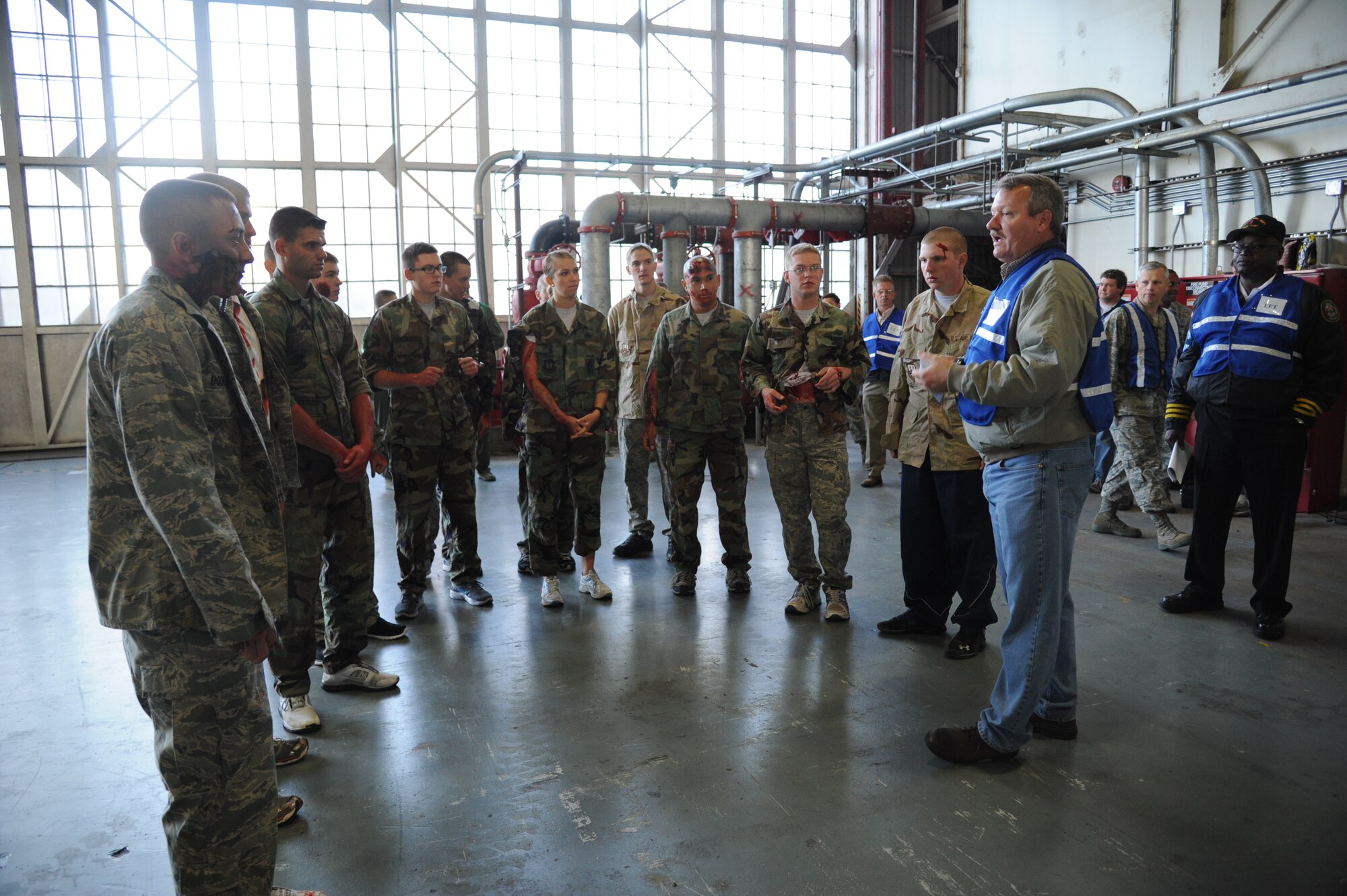 Thane Halsey, 81st Training Wing installation exercise program chief, briefs the “victims” on the exercise scenario prior to the start of the hazardous material and major accident response exercise Oct. 31, 2012, at Hangar 4, Keesler Air Force Base, Miss.  The exercise scenario consisted of a group of Airmen cleaning inside the hangar in preparation for demolition when a shelf holding old munitions fell to the ground causing one to break open, explode and splash an “oily substance” on several of the “victims.”  The exercise helped prepare first responders in the event of a real-world incident.  (U.S. Air Force photo by Kemberly Groue)
