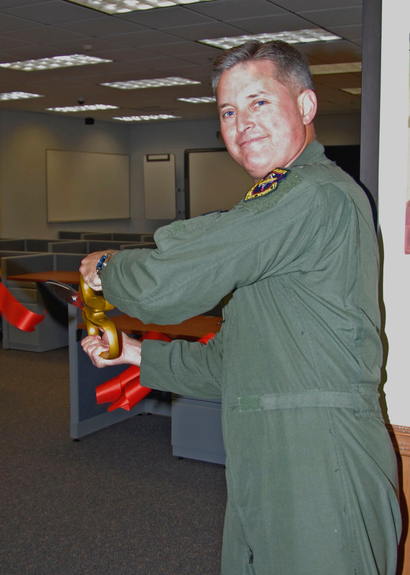 Col. Lawrence Hoffman, United States Air Force Test Pilot School commandant cuts the ribbon after completion of the first classroom renovation at the school in 15 years. The renovations better support the curriculum, Air Force trends and give students the necessary resources to better prepare them for their futures in test and development. (U.S. Air Force Photo by Laura Mowry)