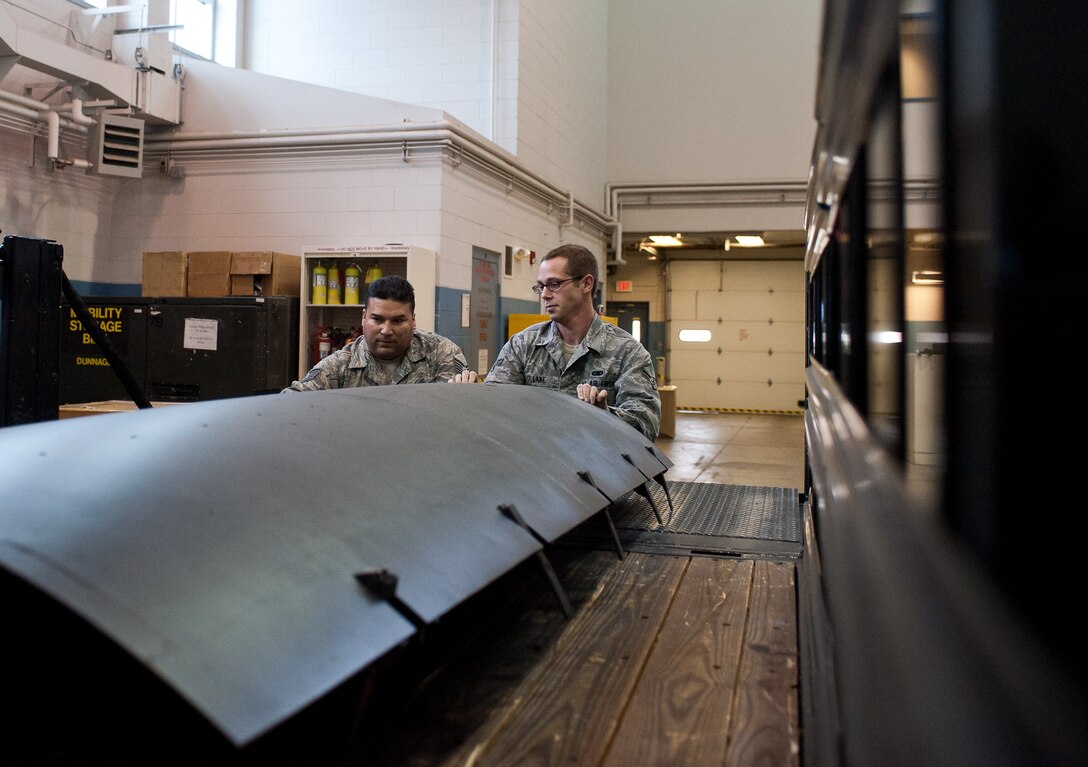 Tech. Sgt. Eric Piar and Airman 1st Class Joshua Lake 28th Aircraft Maintenance Squadron combat oriented supply organization technicians, load a lower engine cowl into a truck bed for delivery at Ellsworth Air Force Base, S.D., Oct. 25, 2012. Parts are delivered to maintenance back shops to be fixed and sent back to maintainers to ensure Ellsworth’s B-1s stay fit to fly. (U.S. Air Force photo by Airman 1st Class Alystria Maurer/Released)