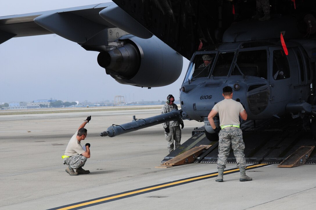 California Air National Guardsmen from the 129th Logistics Squadron loads a HH60G Pave Hawk helicopter into a C17 Globemaster III at Moffett Federal Airfield, Calif., Oct 29, 2012.  More than 100 guardsmen from the 129th Rescue Wing  prepare to mobilize to the East Coast to assist with Hurricane Sandy rescue efforts.  Two MC-130P Combat Shadow aircraft, two HH-60G Pave Hawk rescue helicopters and two Guardian Angel Pararescue teams mobilized to the East Coast to provide life-saving rescue capabilities to those in need in the aftermath of Hurricane Sandy.  (Air National Guard photo by Tech. Sgt. Ray Aquino/RELEASED)