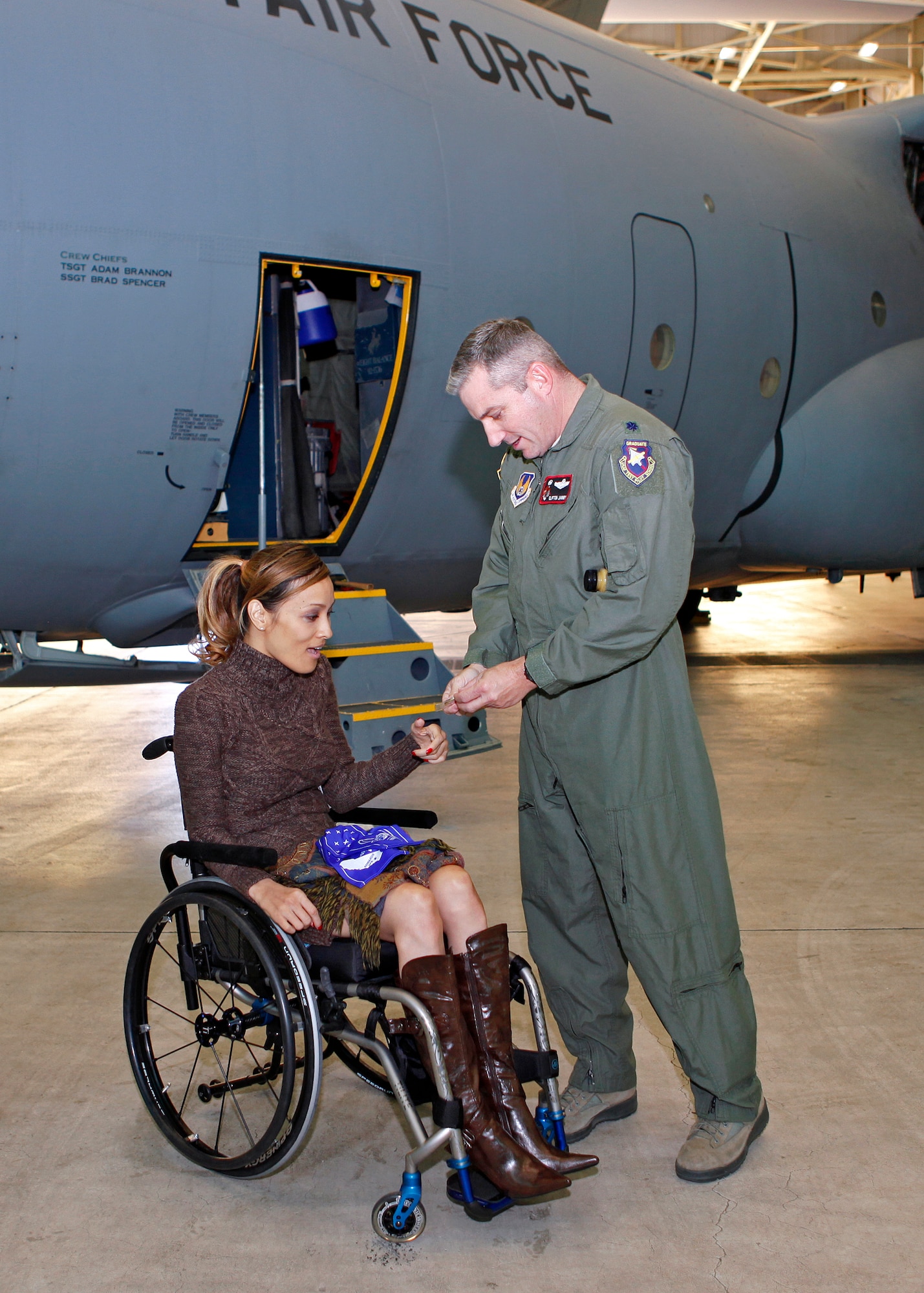 Angela Rockwood, producer and TV reality star of the new Sundance Channel reality show "Push Girls," receives a commander's coin from Lt. Col. Clifton Janney, 418th Flight Test Squadron commander. Rockwood had an opportunity to meet with engineers from the 418th FLTS Oct. 25, as part of her tour of Edwards Air Force Base, Calif.