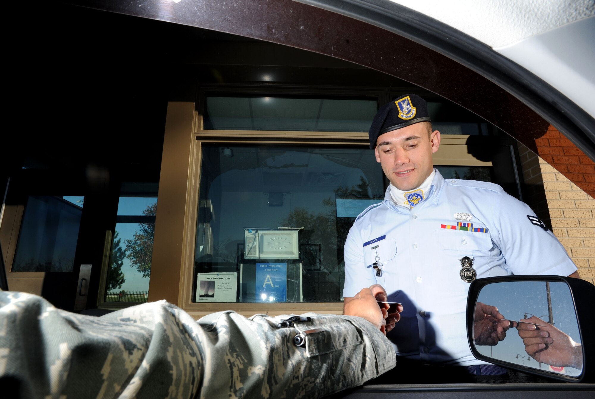 Airman 1st Class Kyle Black, 22nd Security Forces Squadron entry controller, checks an Airman’s common access card at the gate Oct. 31, 2012, McConnell Air Force Base, Kan. Black was chosen as the spotlight performer for the week of Oct. 29 to Nov. 2, for his dedication to the 22nd Air Refueling Wing commander's intents. (U.S. Air Force photo/Senior Airman Laura L. Valentine)