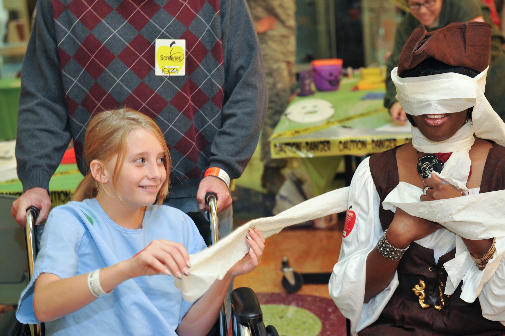 AURORA, Colo. – Mikayla, a Children’s Hospital Colorado patient, wraps April Dobson, a volunteer from the 460th Operations Group, like a mummy Oct. 29, 2012 at the hospital. Dobson was one of 13 volunteers who brought Halloween spirit to children unable to trick or treat. (U.S. Air Force photo by Airman 1st Class Phillip Houk)
