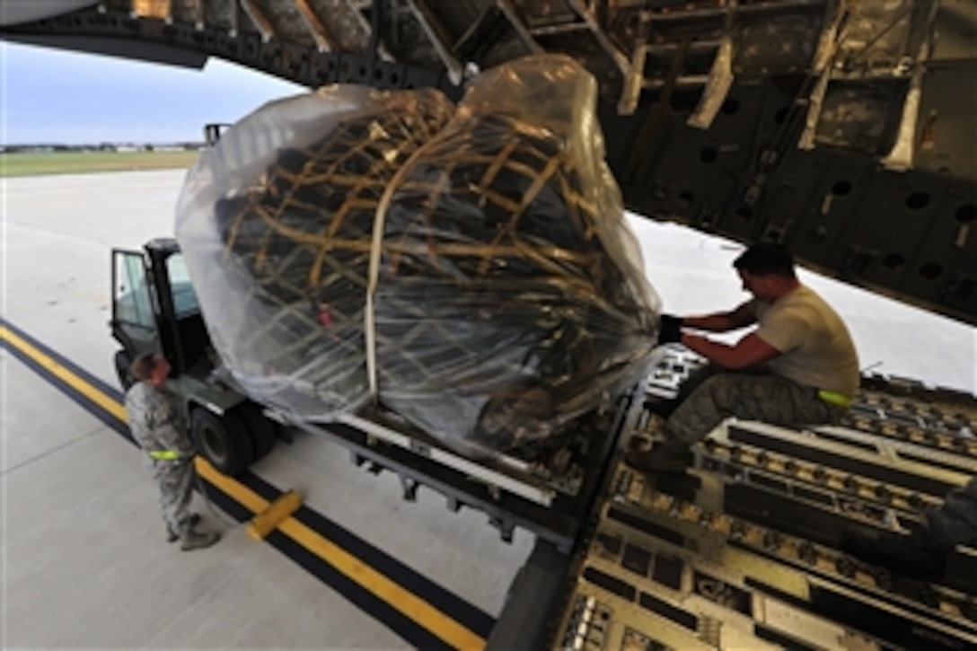 U.S. Air Force Senior Airman Daniel Rose pulls a baggage pallet aboard a C-17 Globemaster III at Joint Base McGuire-Dix-Lakehurst, N.J., on Oct. 28, 2012.  The aircraft was deploying an air mobility contingency response team to MacDill Air Force Base, Fla., out of the path of Hurricane Sandy.   The deployment will ensure Air Mobility Command maintains the capability to respond to natural disasters or worldwide contingencies.  Rose is an aerial transportation specialist assigned to the 305th Aerial Port Squadron. 