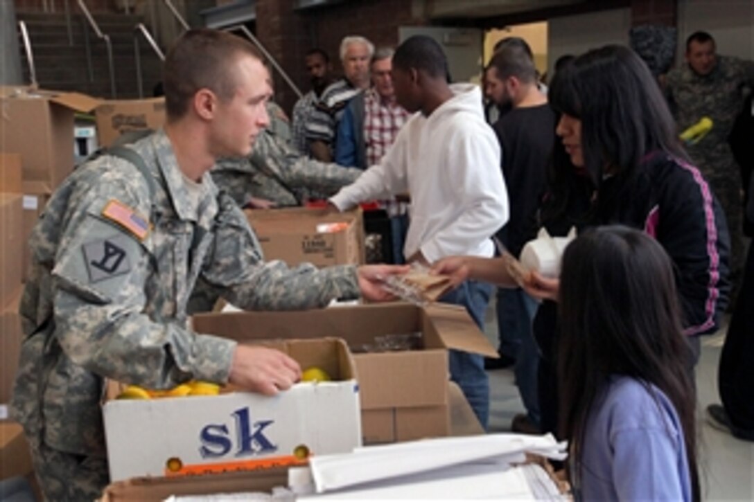 Spc. Anthony Monte passes out food to displaced residents in an emergency shelter at the Werblin Recreation Center, Piscataway Township, N.J., during Hurricane Sandy on Oct. 29, 2012.  Monte and other soldiers from the 50th Infantry Brigade Combat Team, New Jersey Army National Guard, were mobilized to help fellow citizens during Hurricane Sandy.  