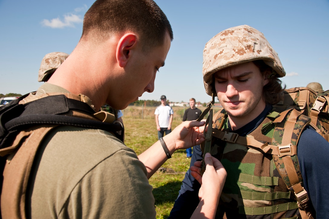 Sgt. Gregory Henry, Marine Heavy Helicopter Squadron 772, assists a Bridgeport Sound Tigers hockey player with his chin strap of the Kevlar helmet during a visit to the base Sept. 30. About 40 members of the Sound Tigers organization visited the base as part of a team-building exercise. The Sound Tigers is a minor league affiliate of the National Hockey League’s New York Islanders. (U.S. Air Force photo by Staff Sgt. David Carbajal/Released)
