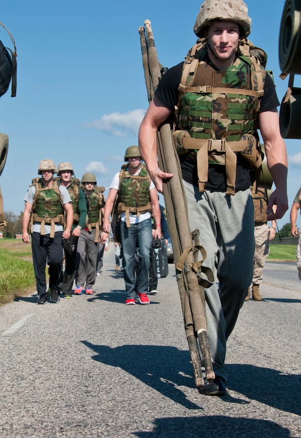 A Bridgeport Sound Tigers hockey player carries his rucksacks and a litter for a 1.5-mile hike to the ranges during the team’s visit to the base Sept. 30. The players and coaches donned Kevlar helmets, flak jackets and their rucks for a hike to the Leadership Reaction Course, where they conducted team-building exercises. The Sound Tigers is a minor league affiliate of the National Hockey League’s New York Islanders. (U.S. Air Force photo by Staff Sgt. David Carbajal/Released)
