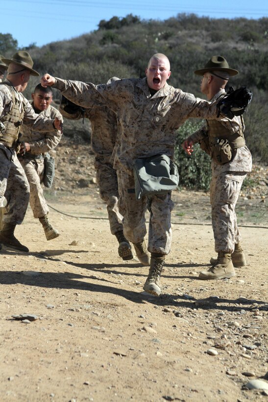 Pvt. Alek Garrett, platoon 3221, Company K, 3rd Recruit Training Battalion, runs out of the Confidence Chamber after being exposed to CS gas, a non-lethal, riot control agent, aboard Marine Corps Base Camp Pendleton, Calif., Oct. 26. Recruits are required to expose their faces twice inside the chamber in order to learn how to properly clear the mask. 