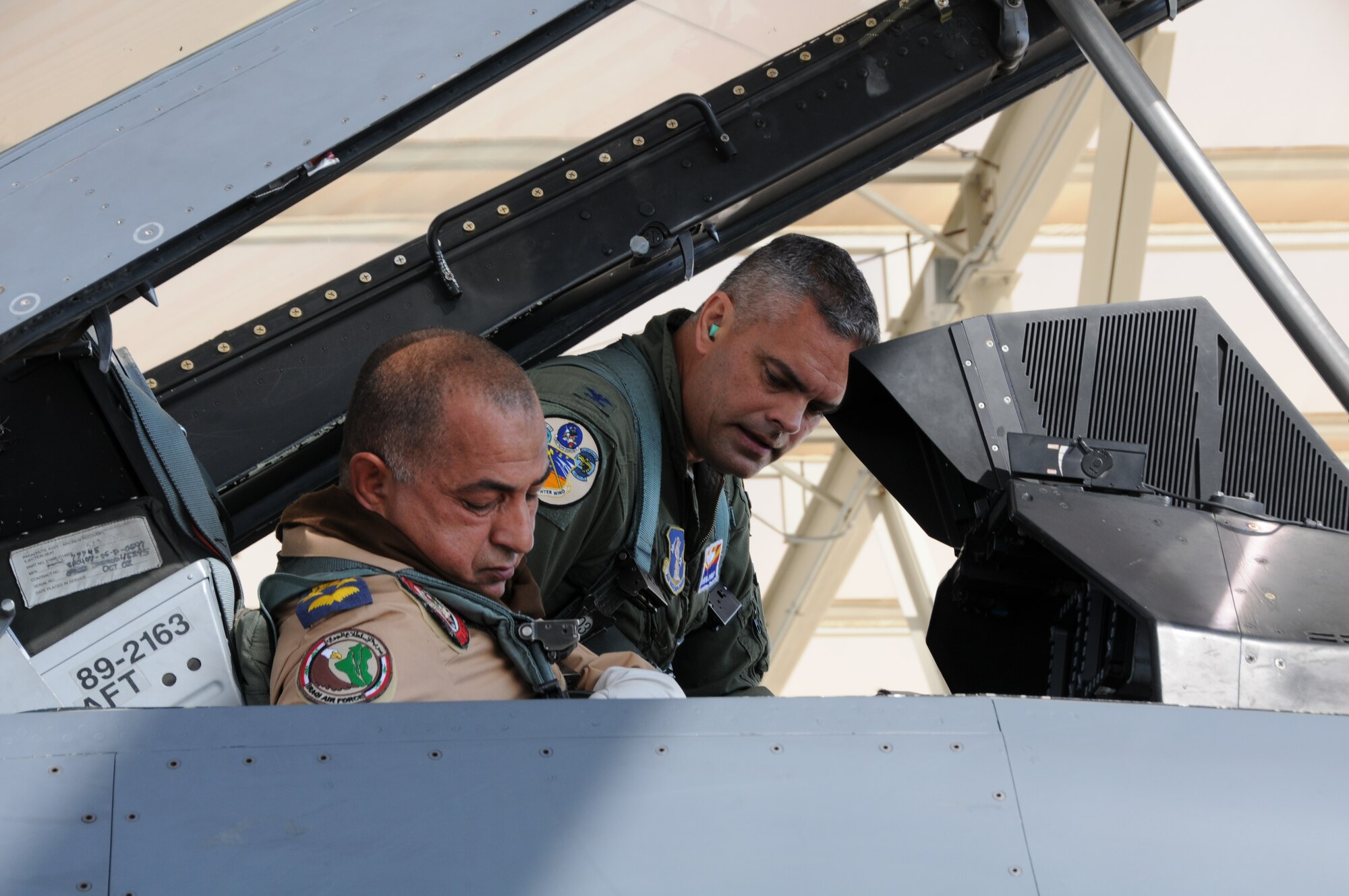 Col. Andrew MacDonald, 162nd Operations Group commander, helps Iraqi Air Force Brig. Gen. Abdulhussein Lafta Ali Ali buckle into an F-16D Fighting Falcon before an orientation flight at Tucson International Airport Aug. 30. Abdulhussein, with a delegation of senior Iraqi officers, visited the international F-16 training wing where Iraqi pilots are learning to fly the multirole fighter. (U.S. Air Force photo/Maj. Gabe Johnson)