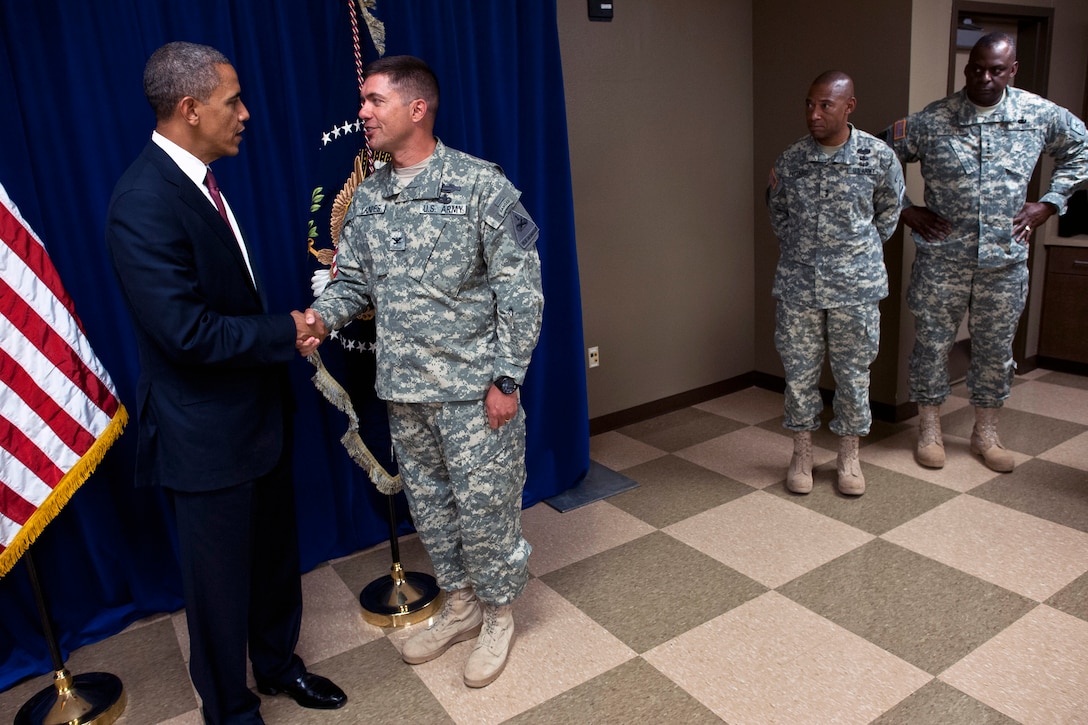 President Barack Obama speaks with Army Col. Mark Landes, commander of 3rd Brigade, 1st Armored Division, on Fort Bliss, Texas, Aug. 31, 2012. 