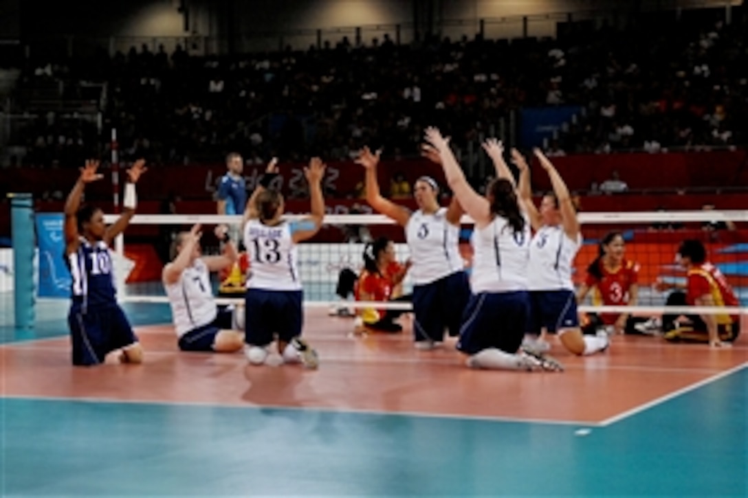 Kari Miller, far left, a former Army sergeant, and other members of the U.S. women's sitting volleyball team celebrate after scoring a point during match play against China during the 2012 Paralympic Games in London, Aug. 31, 2012.