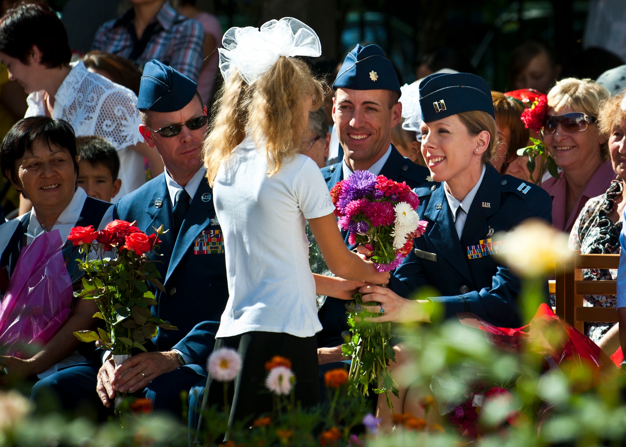 Right, Capt. Martha Petersante receives flowers from a student during a "First Bell" ceremony at the Birdik  School in Bishkek, Kyrgyzstan, Sept. 1, 2012. Flowers were given to teachers and honored guests during the event. (U.S. Air Force photo/Senior Airman Brett Clashman)