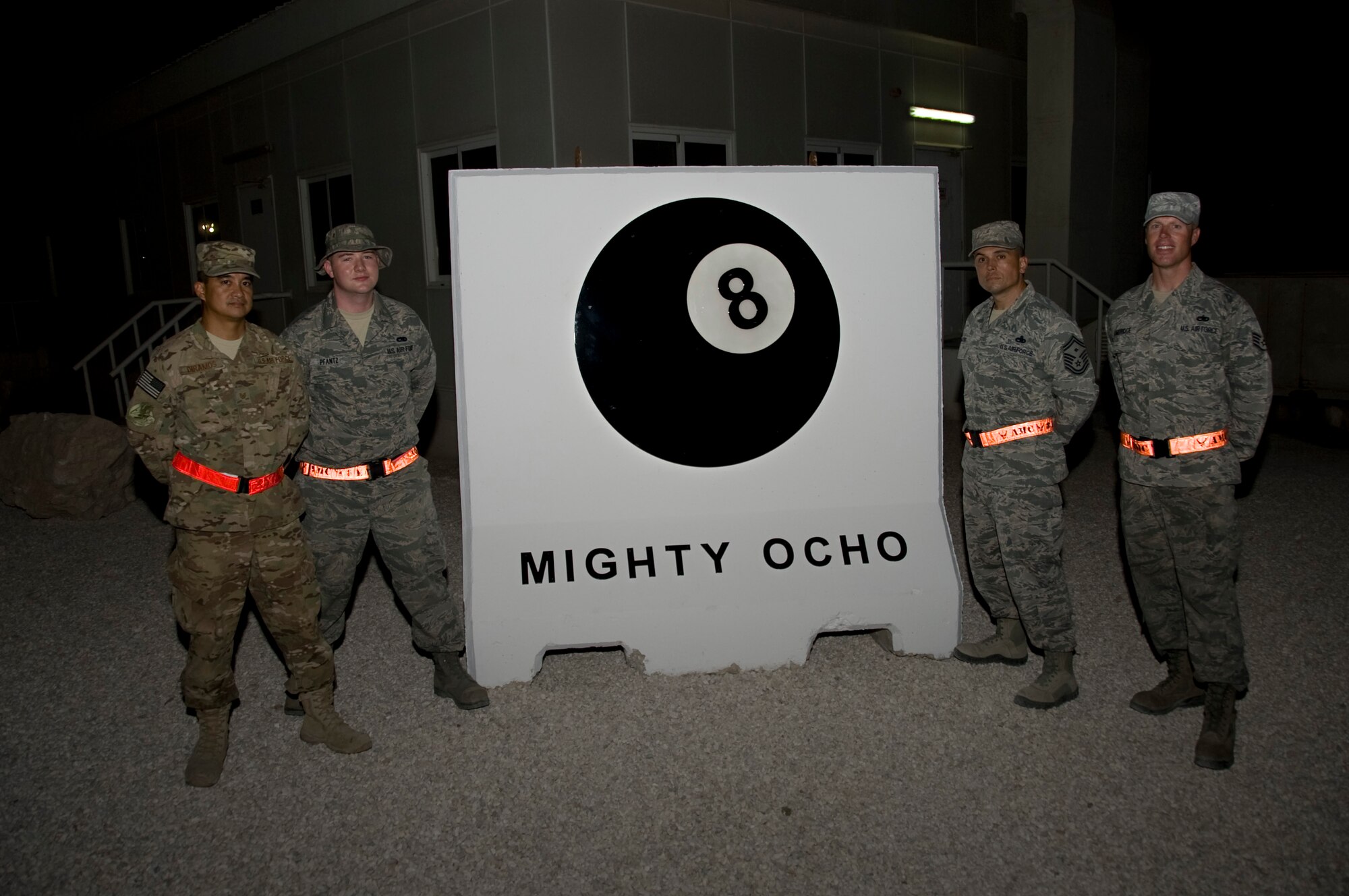 Members of the 8th Expeditionary Air Mobility Squadron lit up the night as they unveiled the squadron's new concrete barrier Aug. 30, 2012. The squadron barrier is the first of its kind here as it has a light that illuminates the eight ball which represents the 8th EAMS squadron, "The OCHOS." (U.S. Air Force photo/Senior Airman Bryan Swink)
