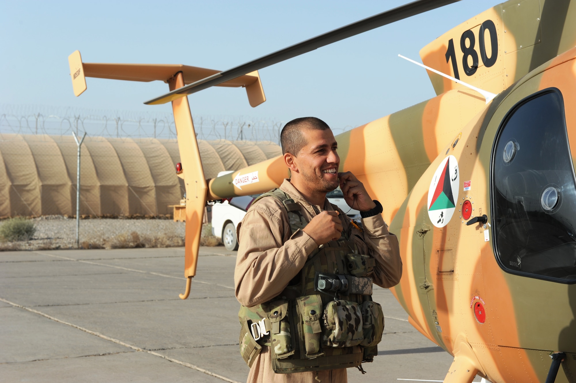 Afghan Air Force Lt. Asifi smiles as he prepares to get inside the MD-530F. Lt Asifi and three other student pilots are part of the MD-530F basic flight training program at Shindand Air Base, Afghanistan. The class of 91-02 is programmed to graduate in early Jan. 2013. (U.S. Air Force photo by Staff Sgt. Melissa K. Mekpongsatorn)