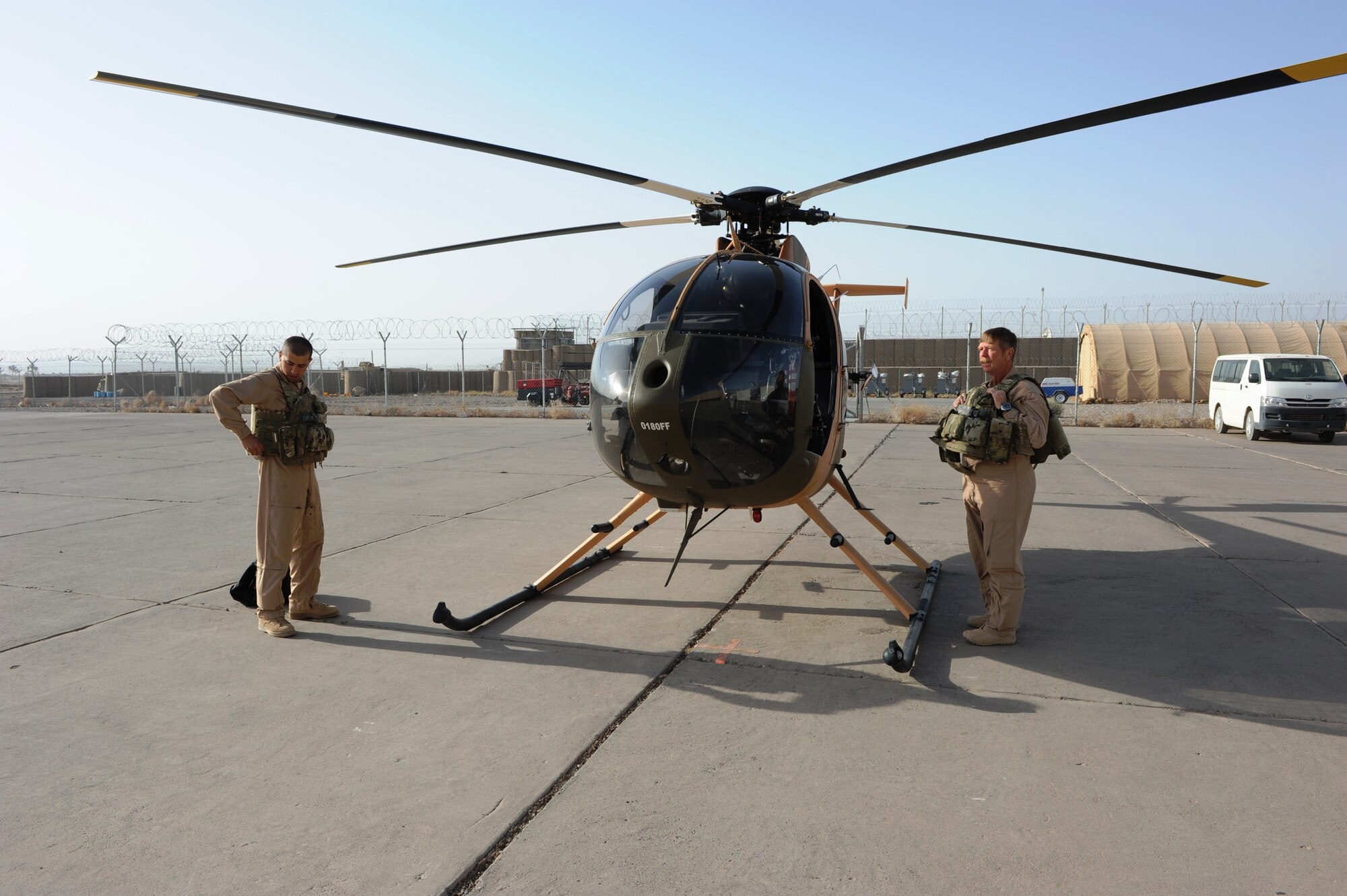Afghan Air Force Lt. Asifi and Mr. Winson Graham, senior pilot instructor, put their gear on prior to getting into the MD-530F Aug 29, 2012 at Shindand AB, Afghanistan. Lt. Asifi is a student pilot in the MD-530F basic flight training program. (U.S. Air Force photo by Staff Sgt. Melissa K. Mekpongsatorn)