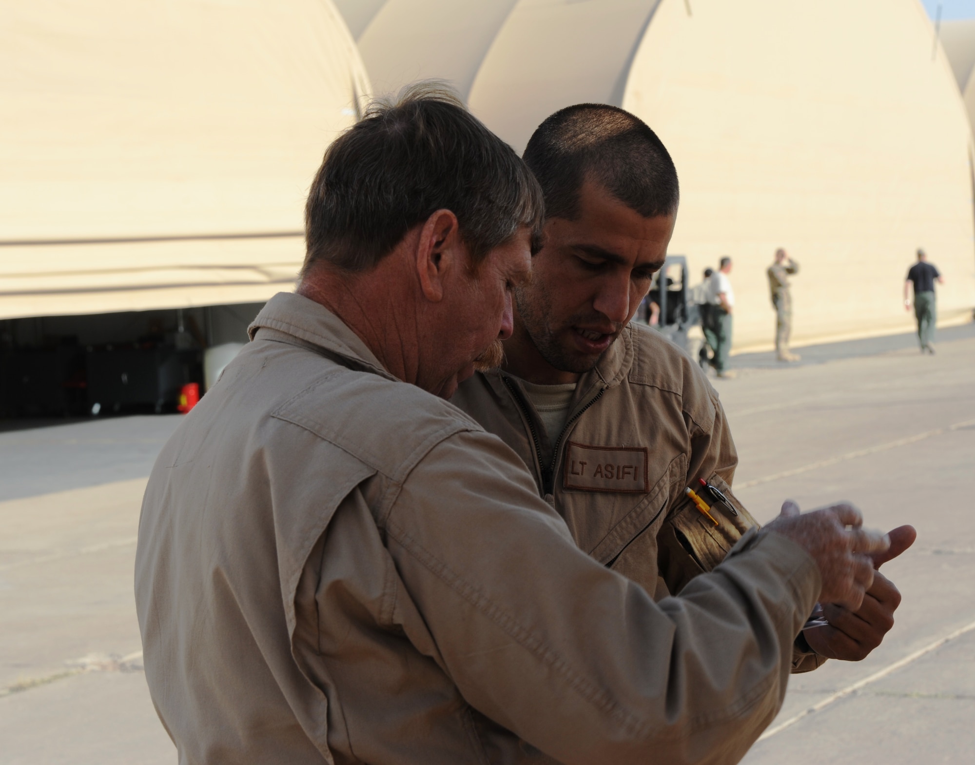 Afghan Air Force student pilot Lt. Asifi and Mr. Winson Graham, senior pilot instructor, prepare to fly by doing pre-flight checks Aug. 29, 2012 at Shindand AB, Afghanistan. Lt. Asifi is one of four Afghan Air Force student pilots part of the MD-530F basic flight training program. (U.S. Air Force photo by Staff Sgt. Melissa K. Mekpongsatorn)