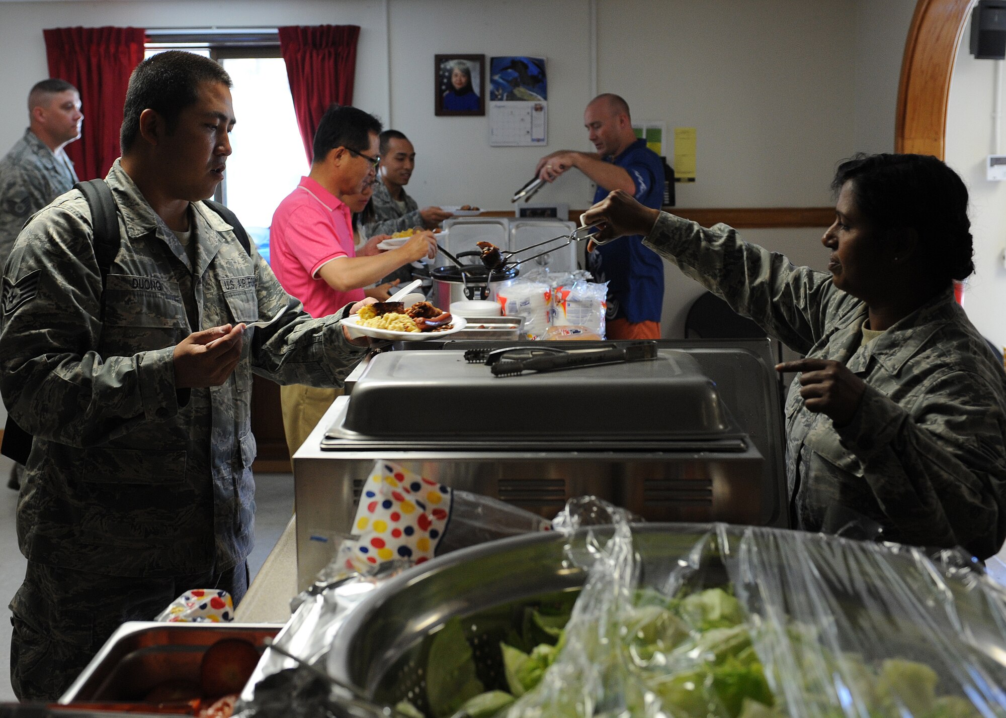 Volunteers serve food to military and civilian personnel during the SonLight Inn open house on Kunsan Air Base, Republic of Korea, Aug. 31, 2012. This unique facility, managed by the Kunsan Chapel, is available daily to the Wolf Pack as a place to gather and socialize in a relaxed environment. (U.S. Air Force photo/Staff Sgt. Jonathan Fowler)