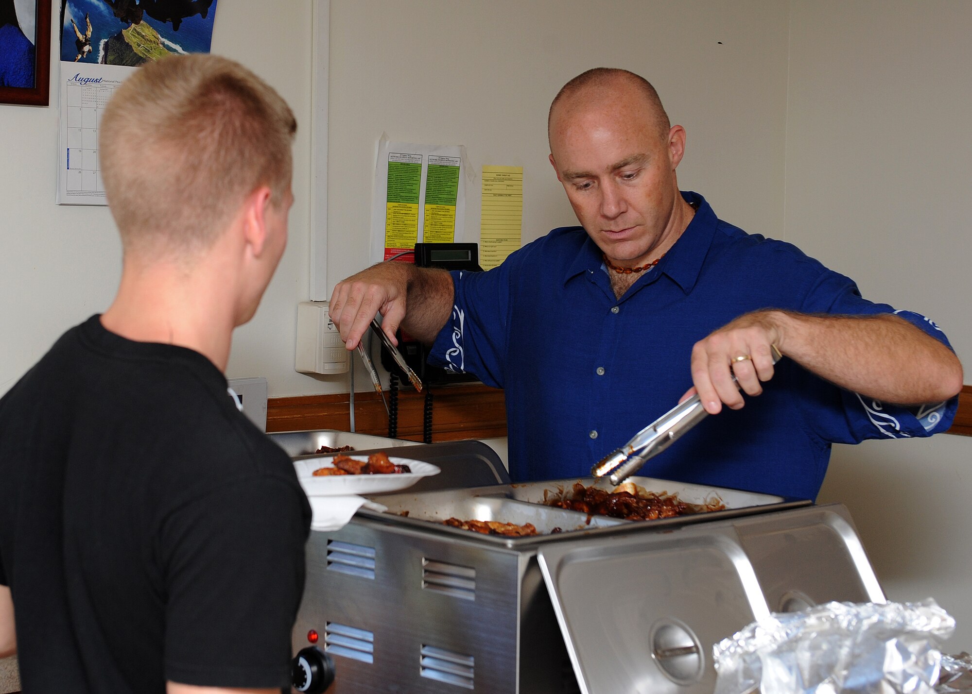 Master Sgt. Bryan Hinton, 8th Maintenance Squadron, serves hot wings during the SonLight Inn open house on Kunsan Air Base, Republic of Korea, Aug. 31 , 2012 . Volunteers and members of the 8th Fighter Wing Chapel served various kinds of food to military and civilians including hot wings, hamburgers and hot dogs. (U.S. Air Force photo/Staff Sgt. Jonathan Fowler)