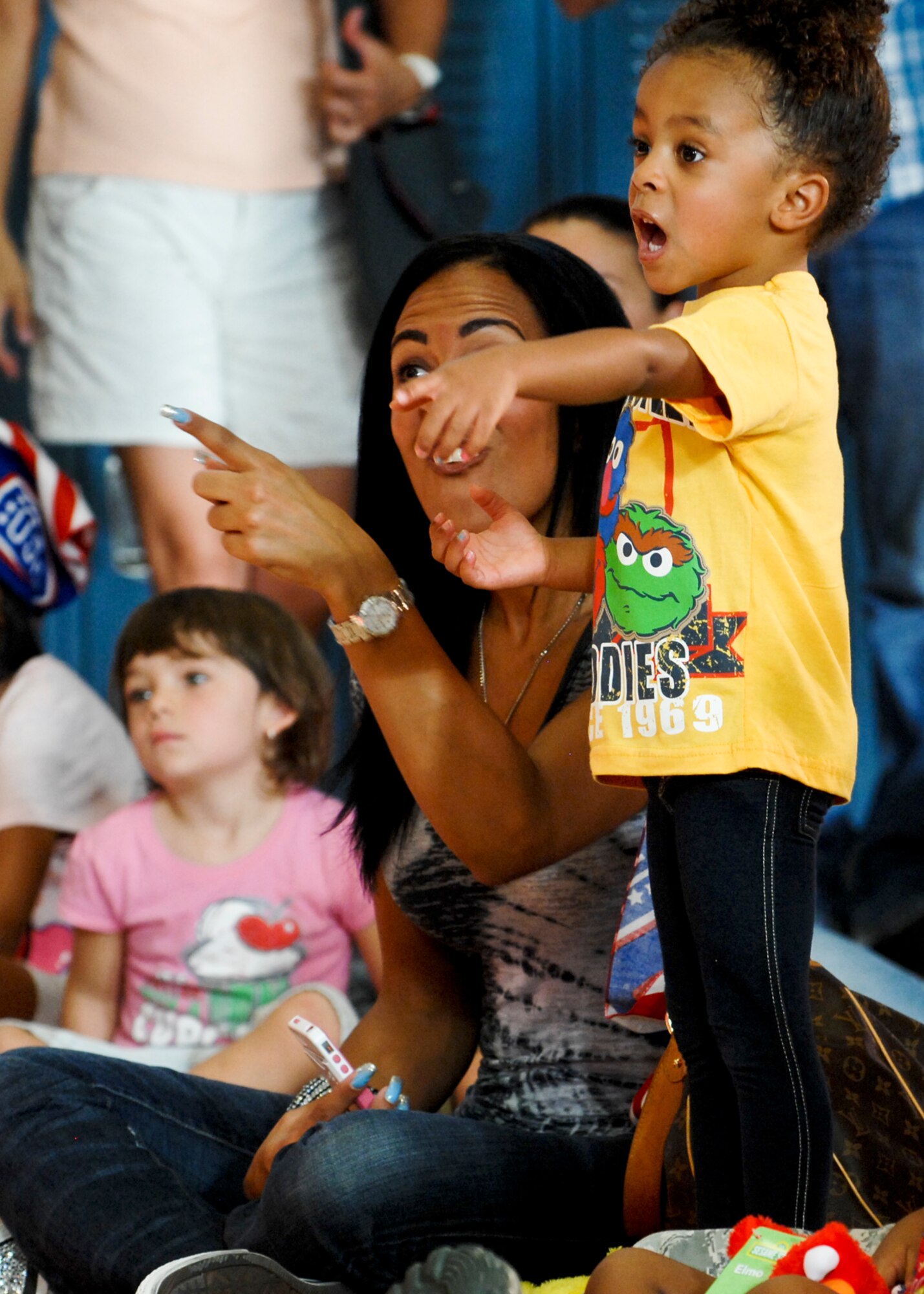 Raegan Doggett, the daughter of Maj. Eric Doggett, 99th Medical Group group practice manager, points at one of her favorite Sesame Street characters during the Sesame Street/USO Experience for Military Families show Aug. 28, 2012 at Nellis AFB, Nev. This years show differs from earlier versions focusing primarily on moving. (U.S. Air Force photo by Senior Airman Jack Sanders)