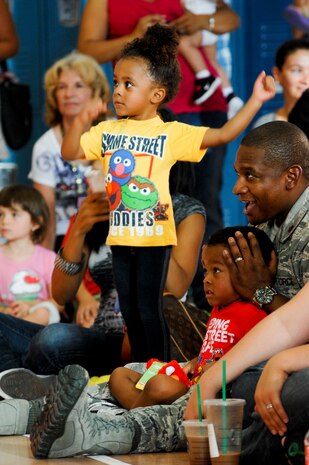 Raegan Doggett, the daughter of Maj. Eric Doggett, 99th Medical Group group practice manager, dances during the Sesame Street/USO Experience for Military Families show Aug. 28, 2012 at Nellis AFB, Nev. Sesame Street has been working with the USO to reach military families since 2008. (U.S. Air Force photo by Senior Airman Jack Sanders)