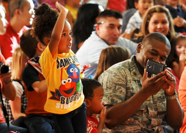 Maj. Eric Doggett, 99th Medical Group group practice manager, photographs his daughter Raegan dancing during the Sesame Street/USO Experience for Military Families show Aug. 28, 2012 at Nellis AFB, Nev. Nellis was the 42nd stop on the tour that will be crossing the continental United States.(U.S. Air Force photo by Senior Airman Jack Sanders)