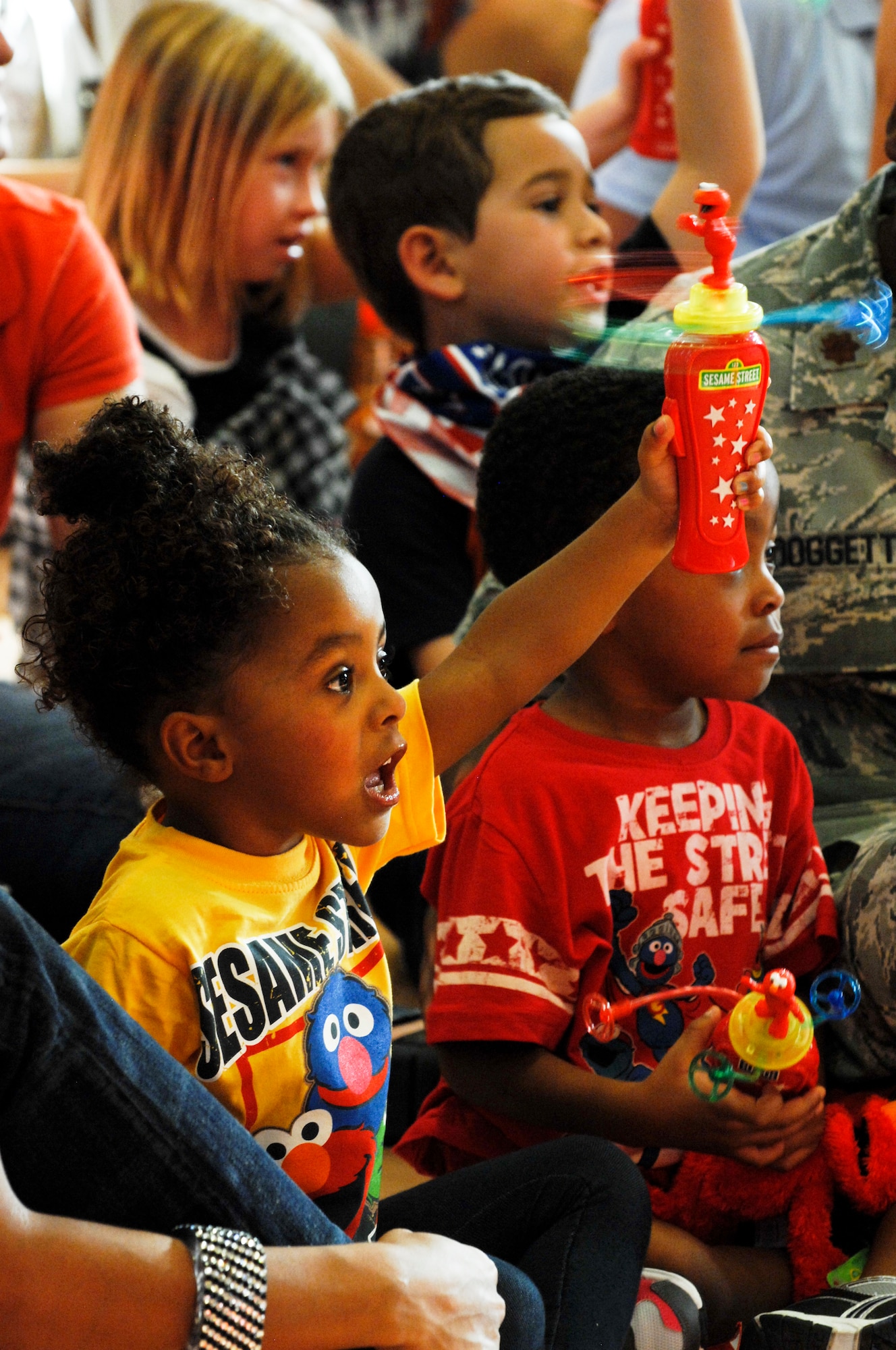 Raegan Doggett, daughter of Maj. Eric Doggett, 99th Medical Group group practice manager, plays with a Sesame Street toy before the Sesame Street/USO Experience for Military Families show Aug. 28, 2012 at Nellis AFB, Nev. Sesame Street spoke about the challenges of moving to military families at Nellis. (U.S. Air Force photo by Senior Airman Jack Sanders)