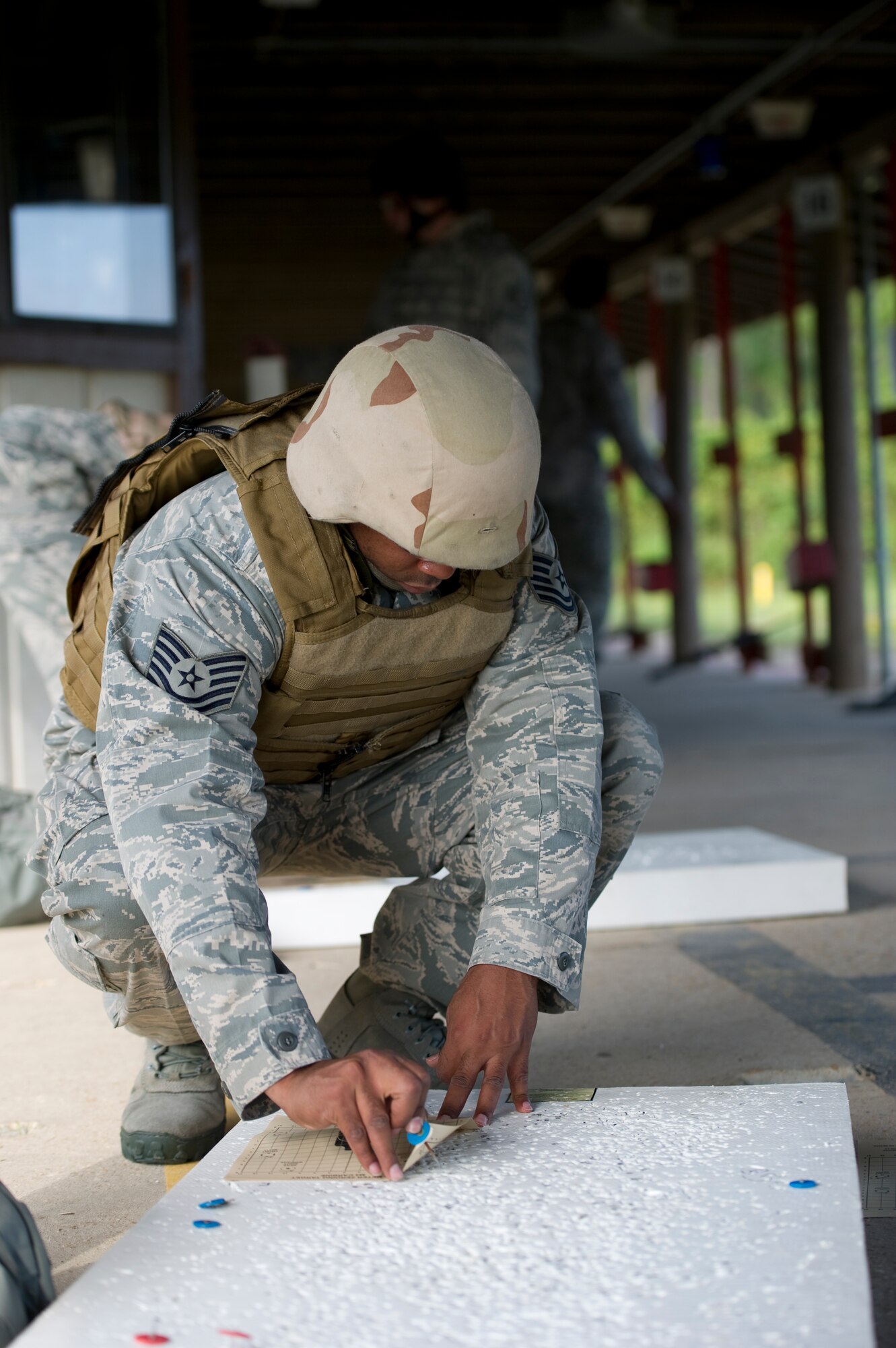 Tech. Sgt. Kenneth Shaheed, a technical support operator of 25th Intelligence Squadron, tacks his target on a foam board at the firing range during a weapons qualification test on Hurlburt Field, Fla., Aug. 23, 2012.  In order to qualify with the M-4, students must get a minimum of 25 hits. (U.S. Air Force Photo/Airman 1st Class Naomi M. Griego)