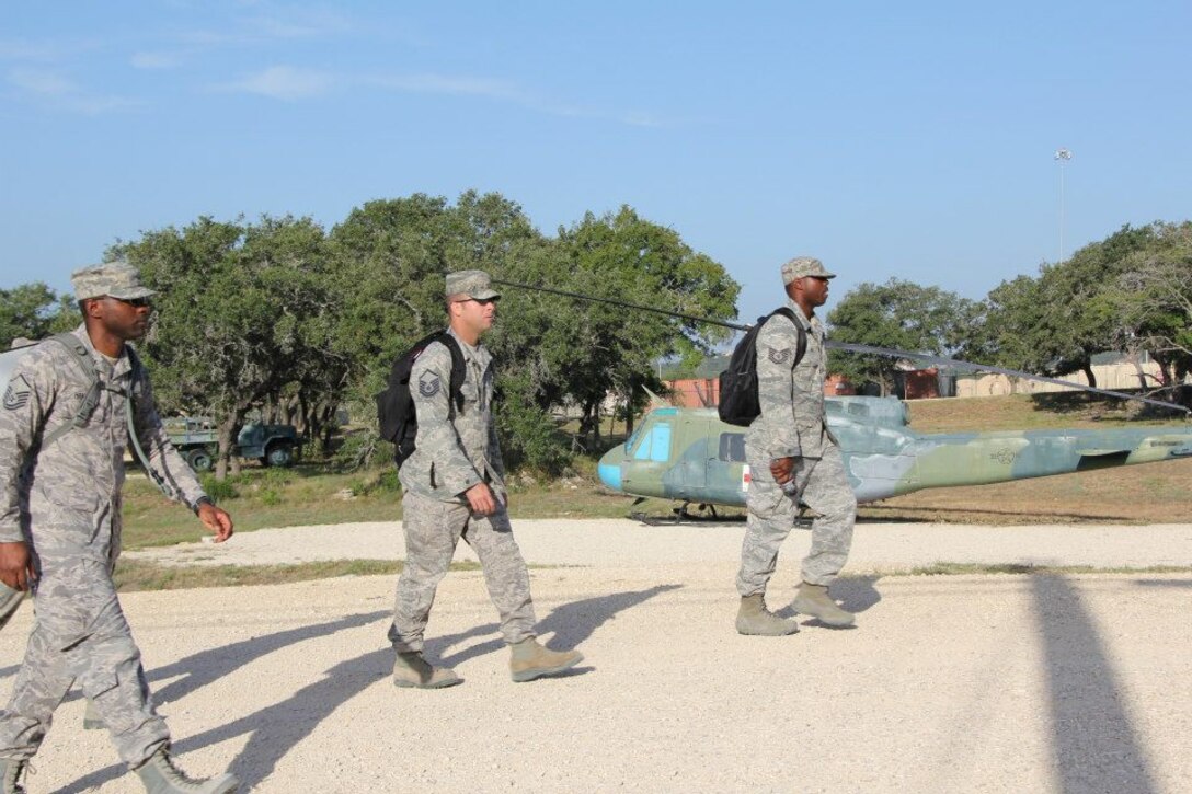 Members from the 932nd Medical Group make their way up a hill past a helicopter to attend specialized outdoor training during their annual tour near San Antonio, Tx.  (U.S. Air Force photo/Maj. Stan Paregien) 
