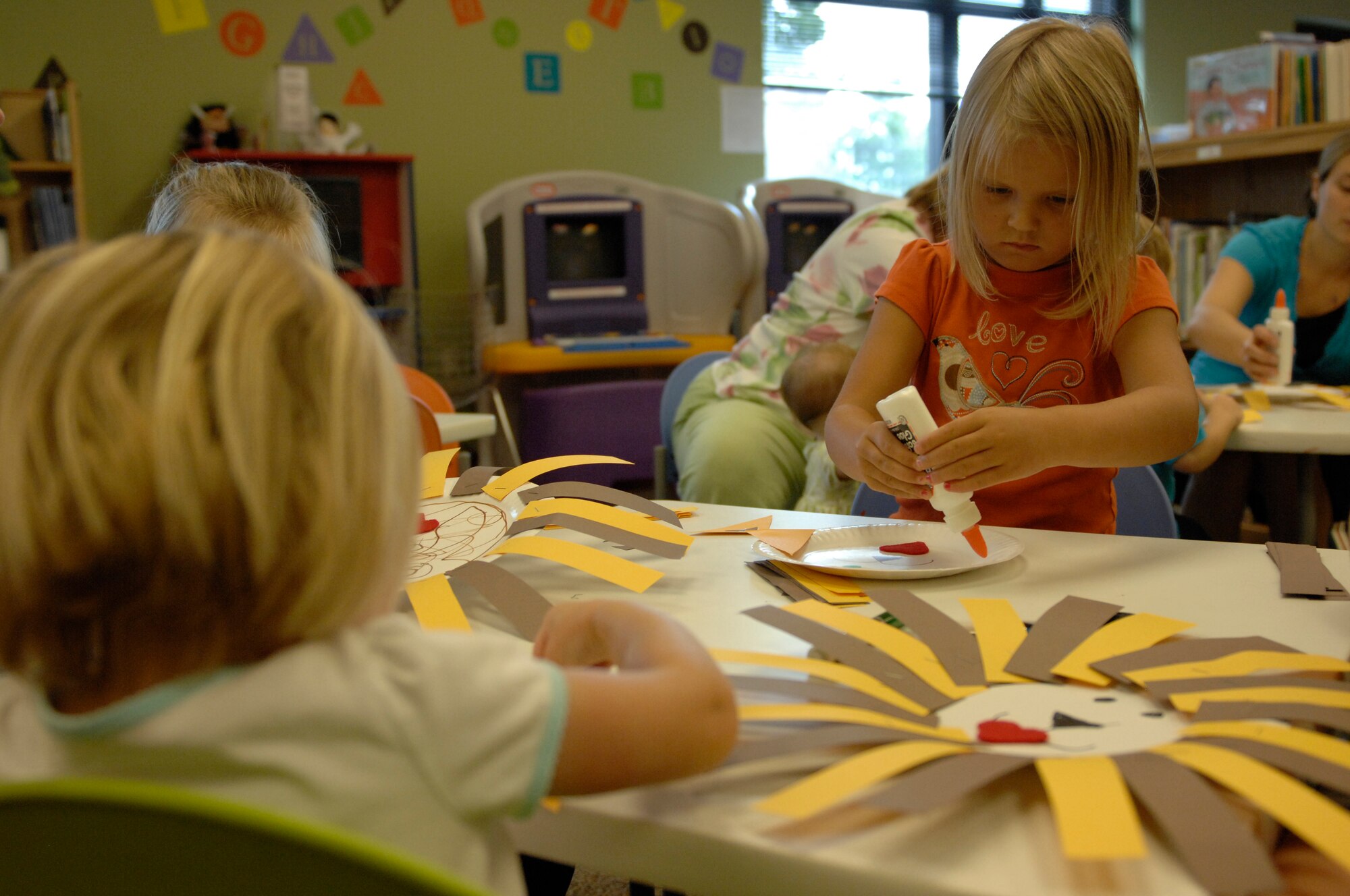 Addison Taylor, the daughter of Staff Sgt. Charles Kropog, 20th Fighter Wing protocol NCO in charge, and other children create paper lion puppets at the Shaw Air Force Base, S.C., library, Aug. 29, 2012. Before the arts and crafts, Marie Stanley, the children's program coordinator, read to them “The Circus Ship” and “Clifford at the Circus.” Every Tuesday at the McElveen Library from 11 a.m. to 12 p.m. and 1 to 2 p.m children are invited to listen to two stories and create a craft. (U.S. Air Force photo by Airman 1st Class Krystal M. Jeffers/Released)