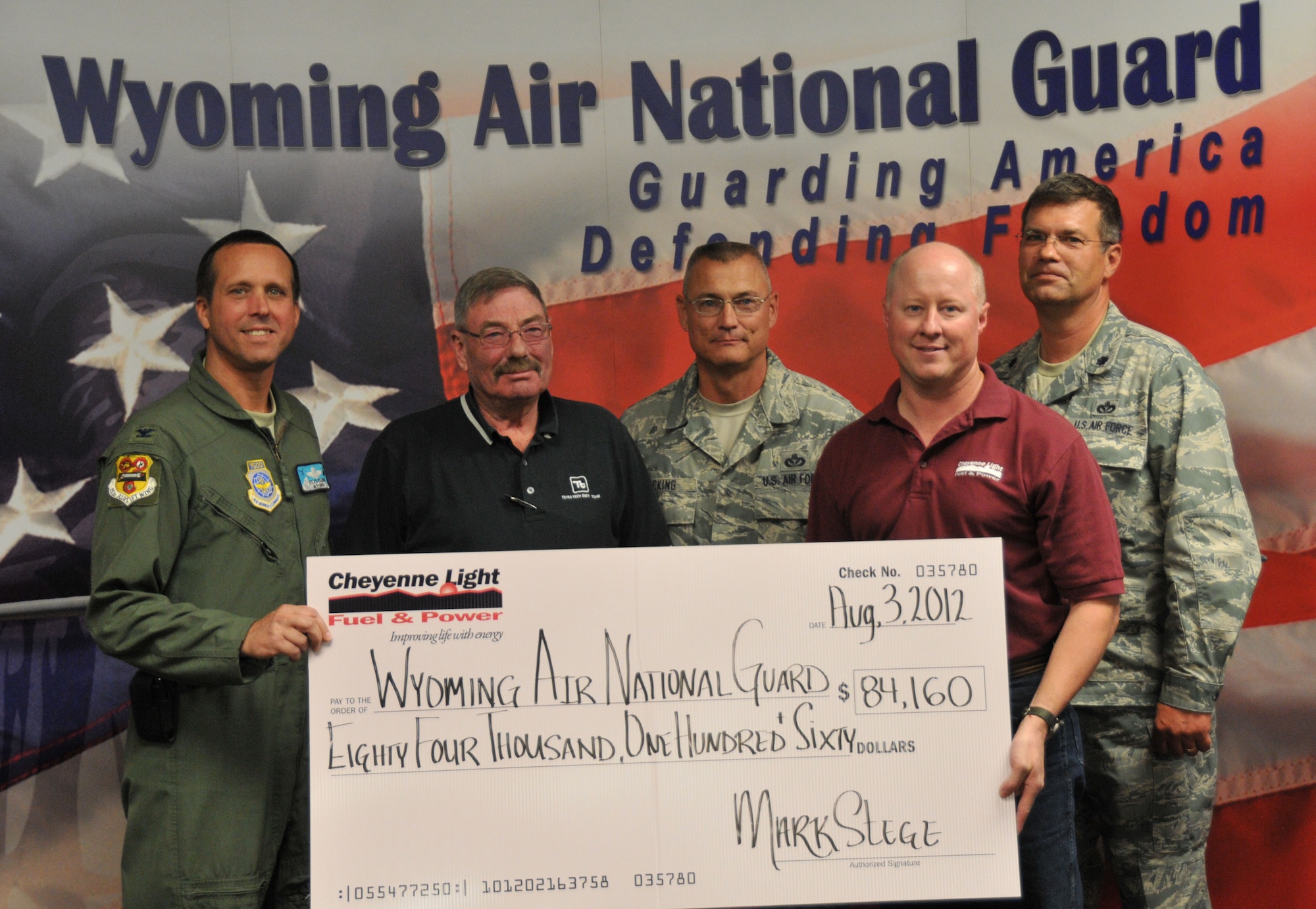 Cheyenne Light, Fuel & Power present a rebate check, for over $84,000, to Wyoming Air National Guard leadership for the steps taken to improve energy efficiency at the WyANG base, Aug. 3, 2012. The Wyoming Air National Guard has taken significant measures to replace dated lighting fixtures with energy efficiency products in several structures at its Cheyenne, Wyo., facilities.