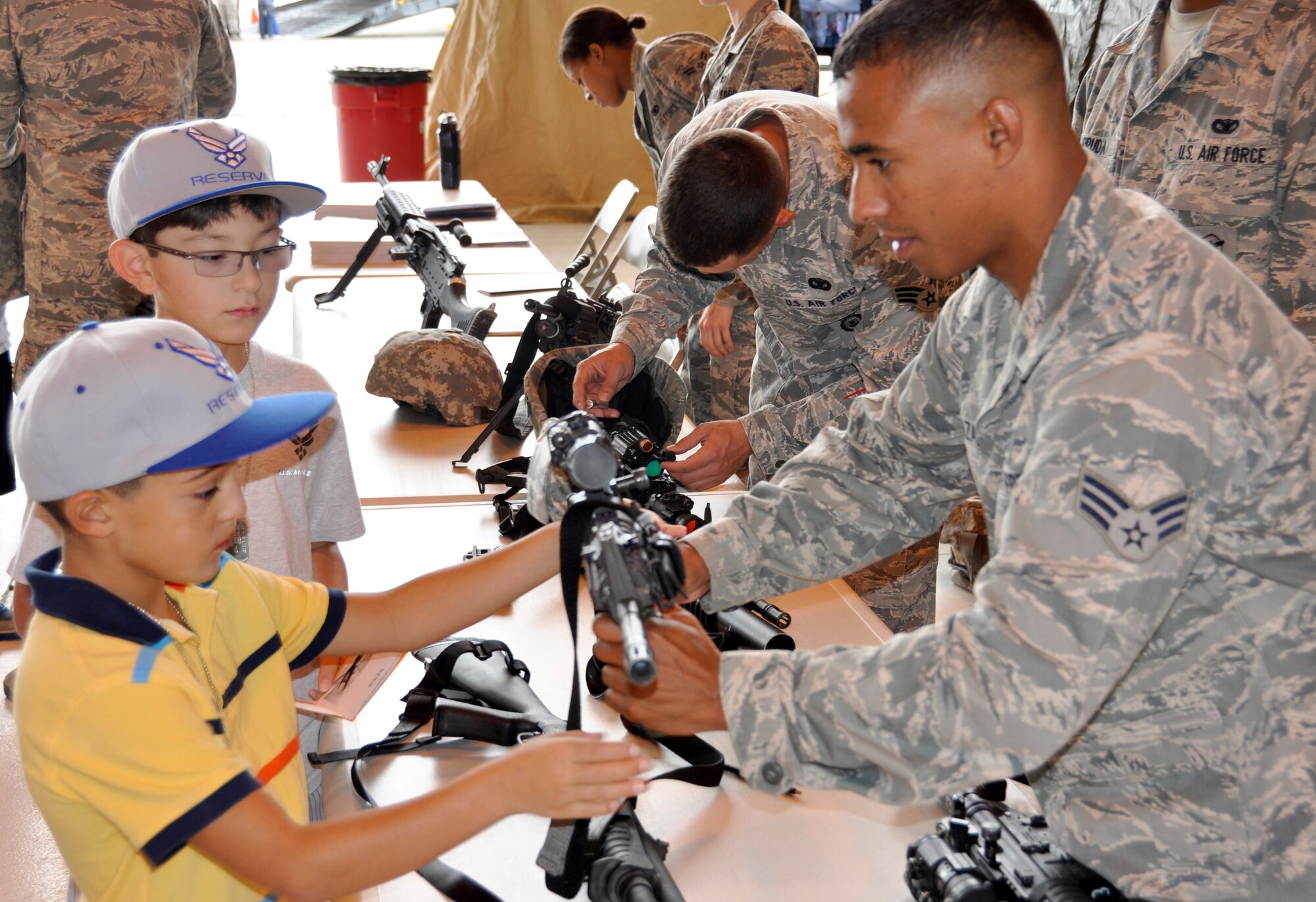 Giovionni, 8, checks out an M-4 automatic rifle with the help of Air Force Reservist Senior Airman Carlos Gonzalez during the 302nd Airlift Wing’s Herc Adventure Tour event Aug. 4, 2012, at Peterson Air Force Base, Colo. The Herc Adventure Tour also offered the children of AF Reservists to experience the wing’s aeromedical evacuation mission, check out the survival gear of C-130 flight crews and sit in the pilot’s seat of a C-130 Hercules. The tour is part of the wing’s annual Family Day event, held directly after. Giovionni is the son of Tech. Sgt. Brian Trujillo, 302nd Aircraft Maintenance Squadron C-130 crew chief. (U.S. Air Force photo/Staff Sgt. Stephen J. Collier)