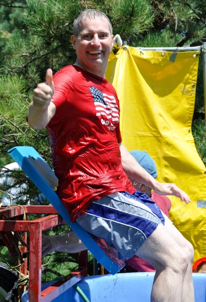 Air Force Reserve Tech. Sgt. Alan Kokes, 302nd Communications Flight, signals he’s ready for more Aug. 4, 2012, as his dunk tank seat gives way during the 302nd Airlift Wing’s 2012 Family Day event at Peterson Air Force Base, Colo. Hundreds of Air Force Reservists assigned to the 302nd AW and their families enjoyed several activities during the annual event, including a Herc Adventure Tour, a display of military weaponry and a picnic lunch. This year’s Family Day also featured a bungy trampoline and a C-130 Hercules simulator. (U.S. Air Force photo/Staff Sgt. Stephen J. Collier)